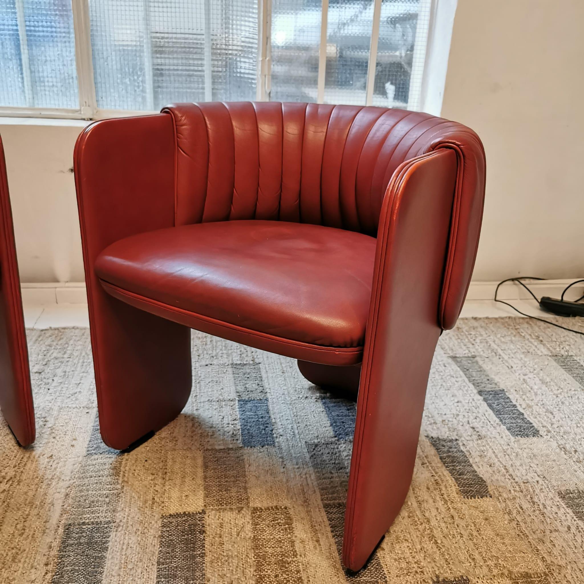 Pair of vintage armchairs entirely in leather designed in the 70s by Luigi Massoni for Poltrona Frau. The armchairs are in red leather and are in excellent condition.