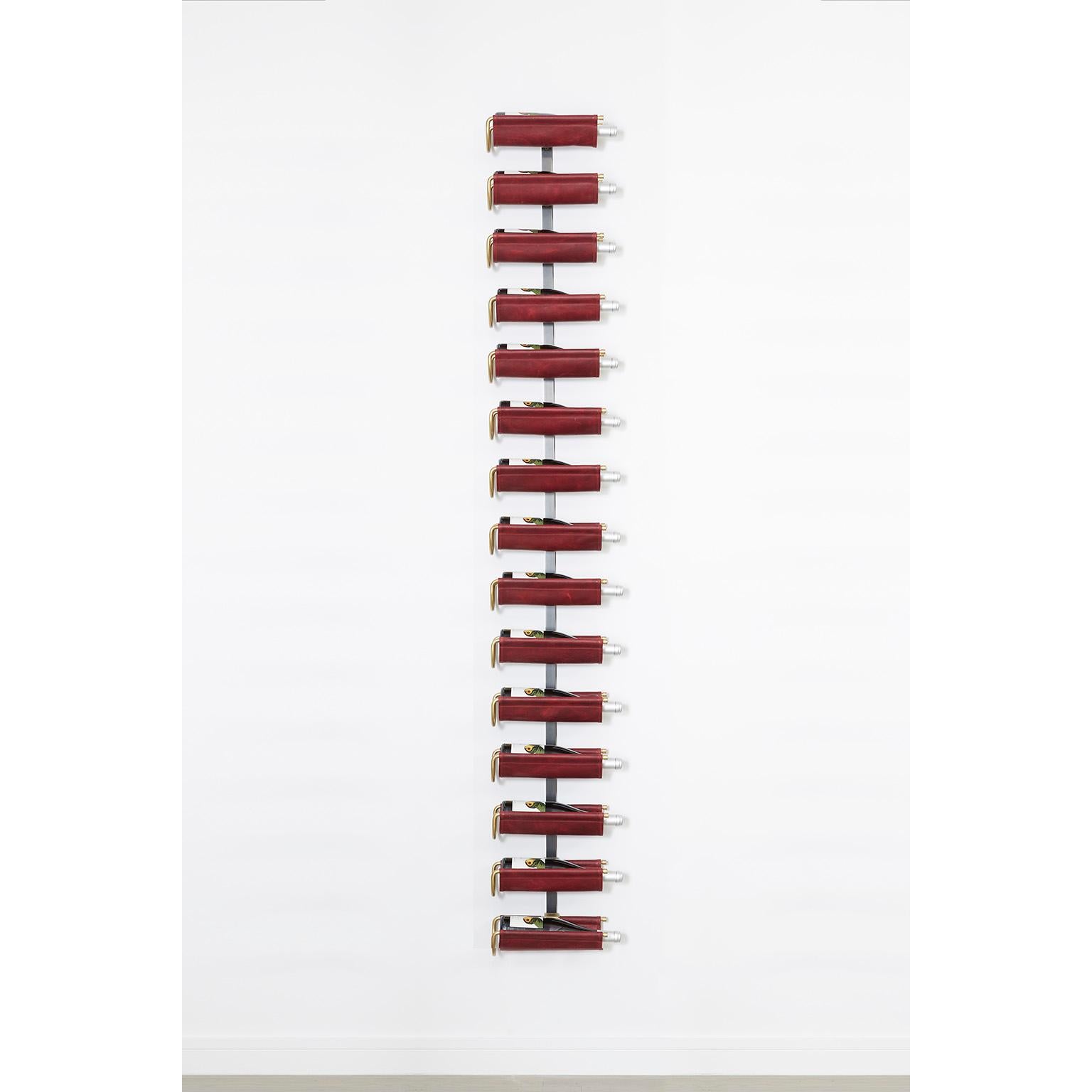 Ce présentoir mural à vin en cuir de selle d'Amuneal est la solution parfaite pour présenter une collection de vins dans un style moderne avec un faible encombrement. Une série d'éléments de quincaillerie usinés en bronze sur mesure permet de