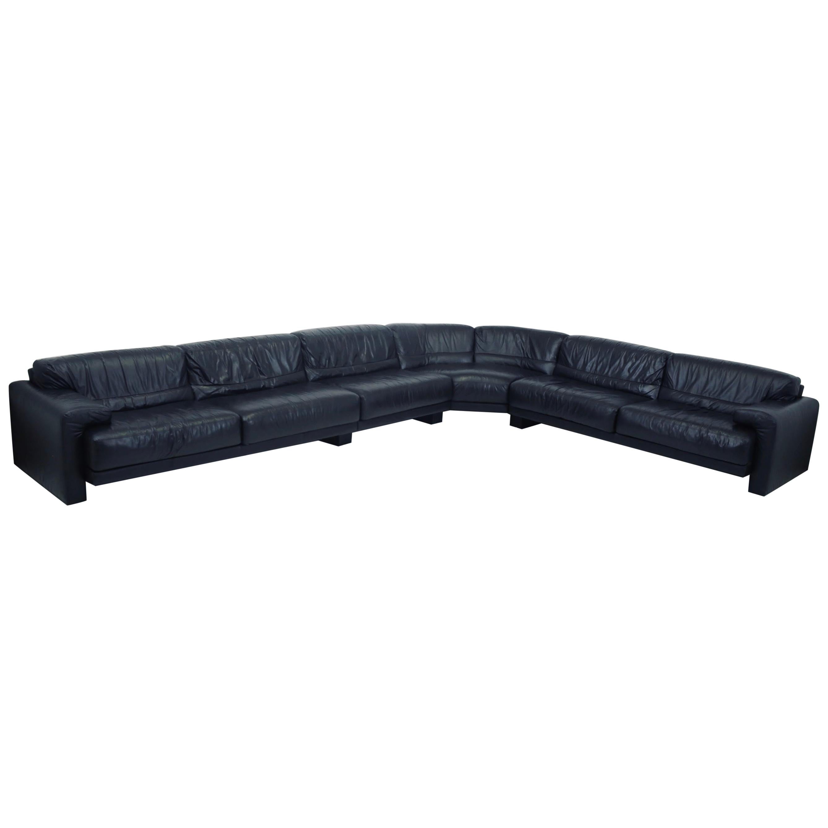 Large scale black leather sectional made by Preview furniture. A sectional version of the “Midday sofa series” produced by Saporiti in 1981. Original leather is in very good condition. Each section is 40” deep. Total measurement is 131” x 176”.