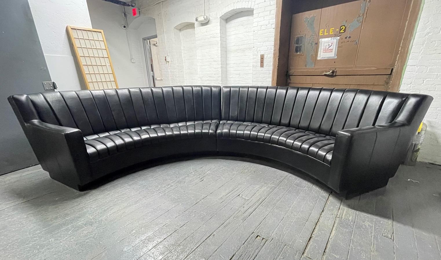 Black leather two-piece sectional sofa designed in the manner of De Sede. Sofa has lights at the bottom with a formica base. Each sectional measures: 96