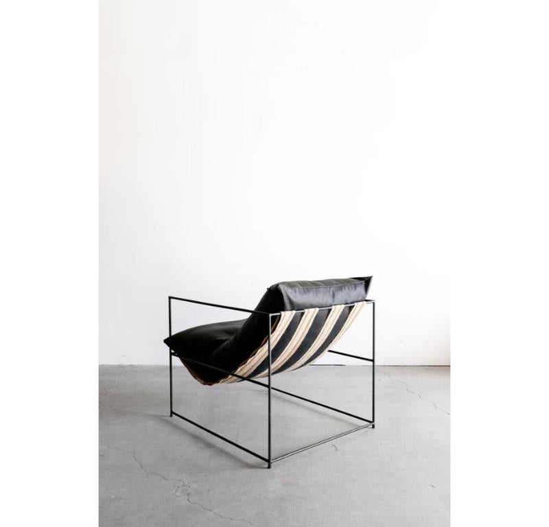 The Leather Sierra Chair in black leather is handmade locally in Los Angeles, California. flagship upholstered piece is regarded for not only its distinct design, but its exceptional comfort as well. An open, thin steel frame allows the design to