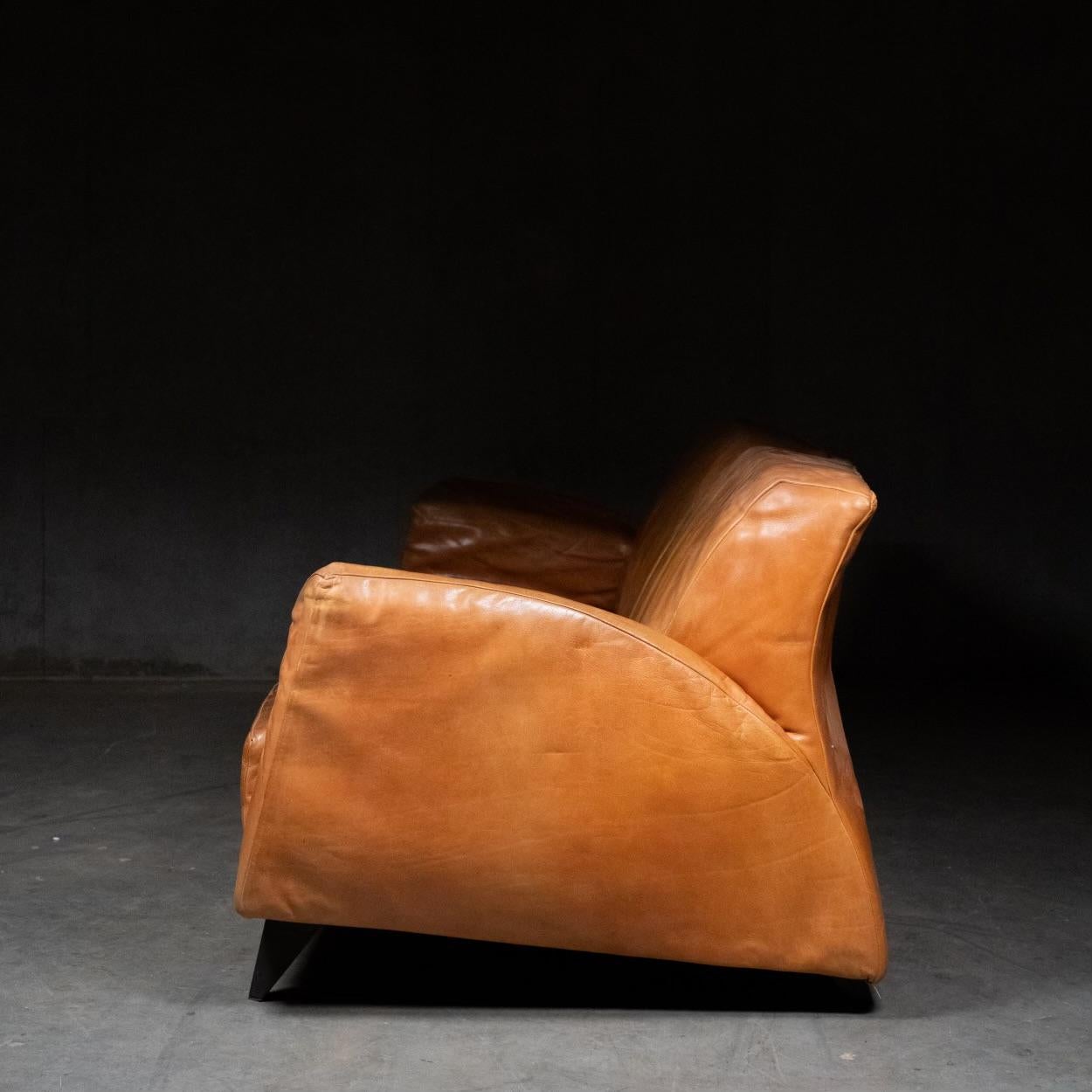 Gerard van den Berg 'Corvette' sofa in cognac leather with tapered metal legs. In original condition with some visible wear and scratching consistent with age and use. 

Acquired from a private collection.
