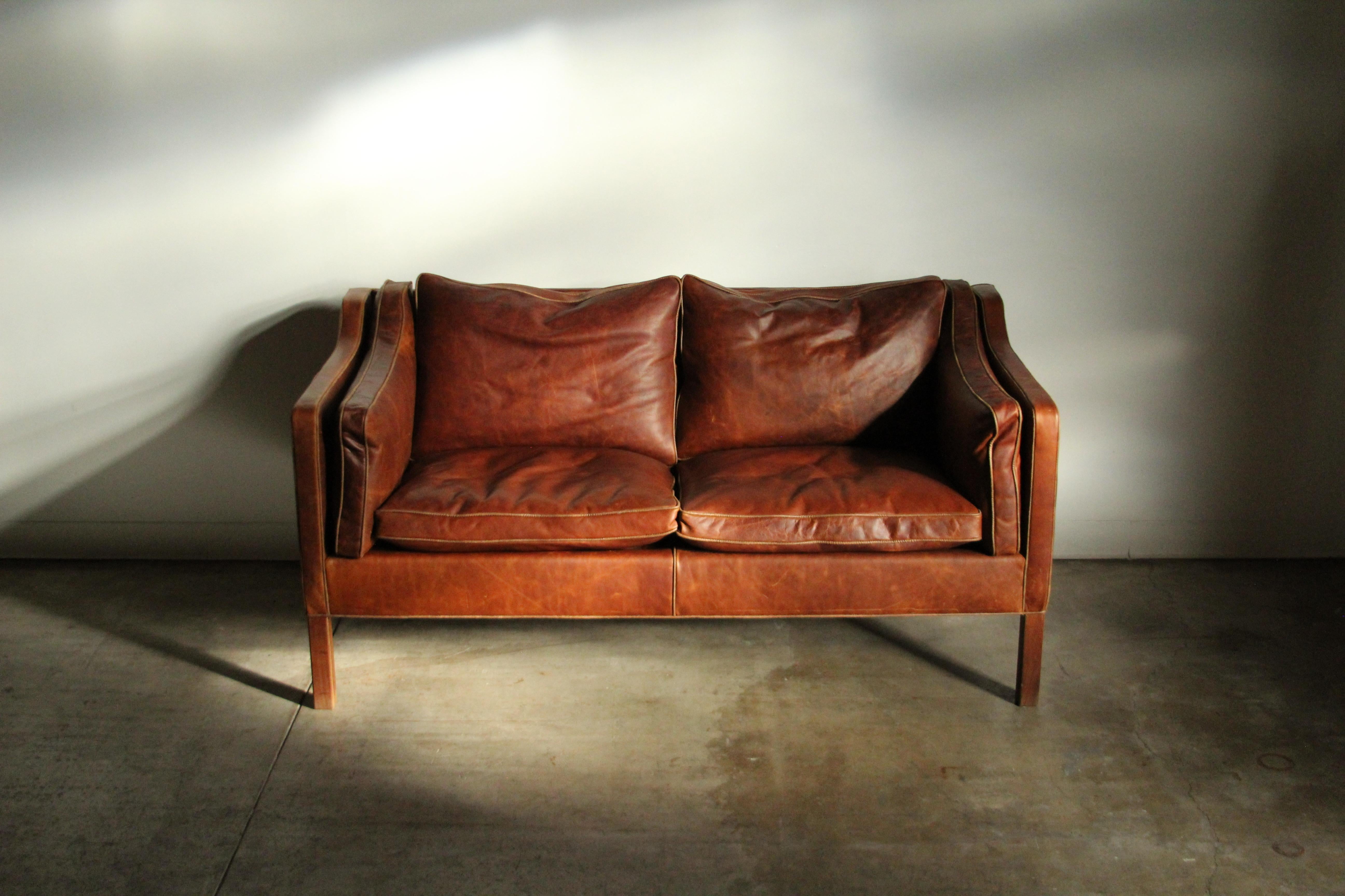 A fabulous leather sofa loveseat designed by the Danish master Borge Mogensen and manufactured by Frederica in the 1950s. This solid little sofa has been freshly reupholstered in thick, top grain, naturally distressed leather. It is so so soft and