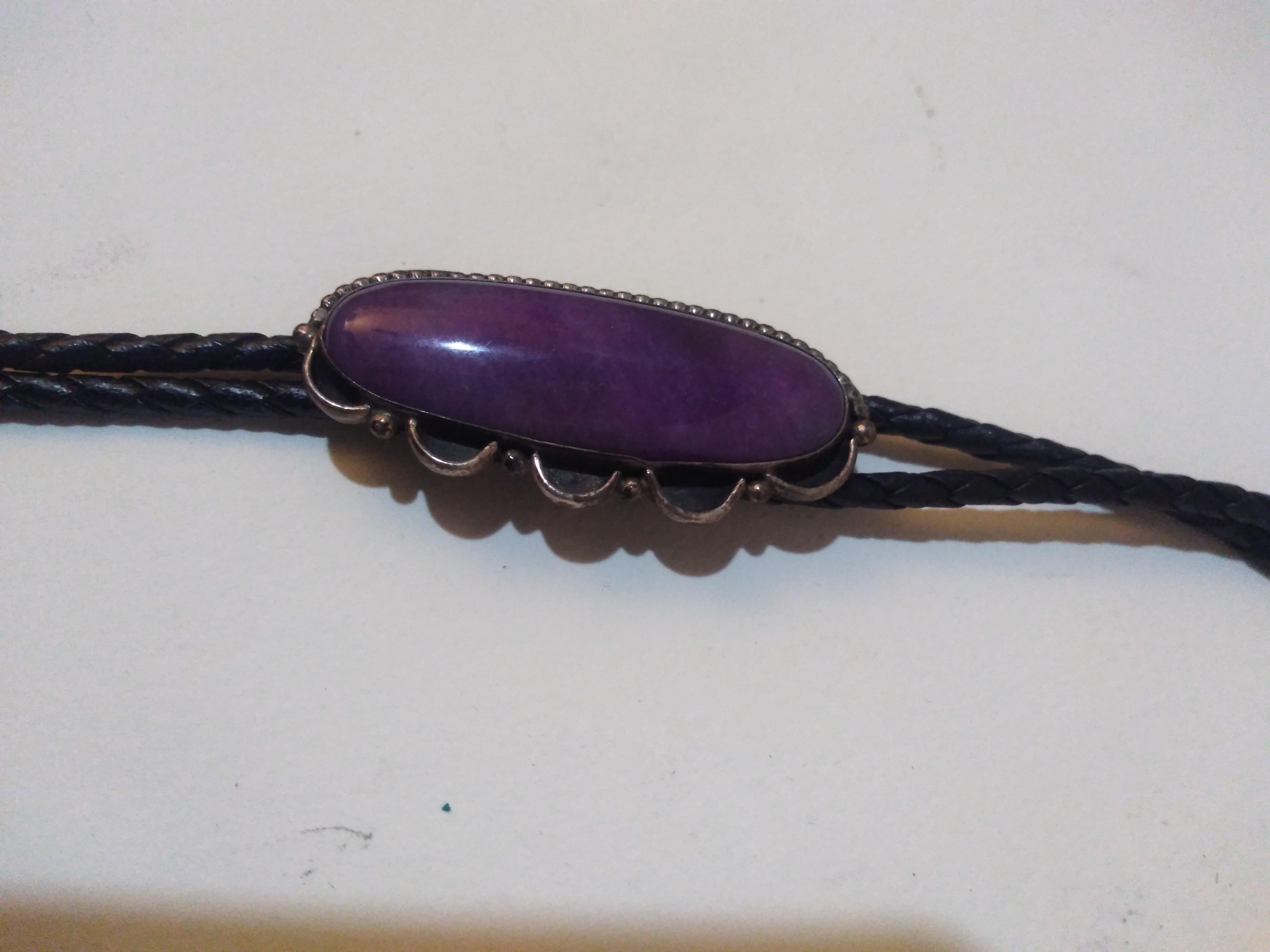 Questa cravatta Bolo è realizzata in pelle e argento. Ha un'incastonatura di Charoite in una conchiglia a forma di vongola con perline.