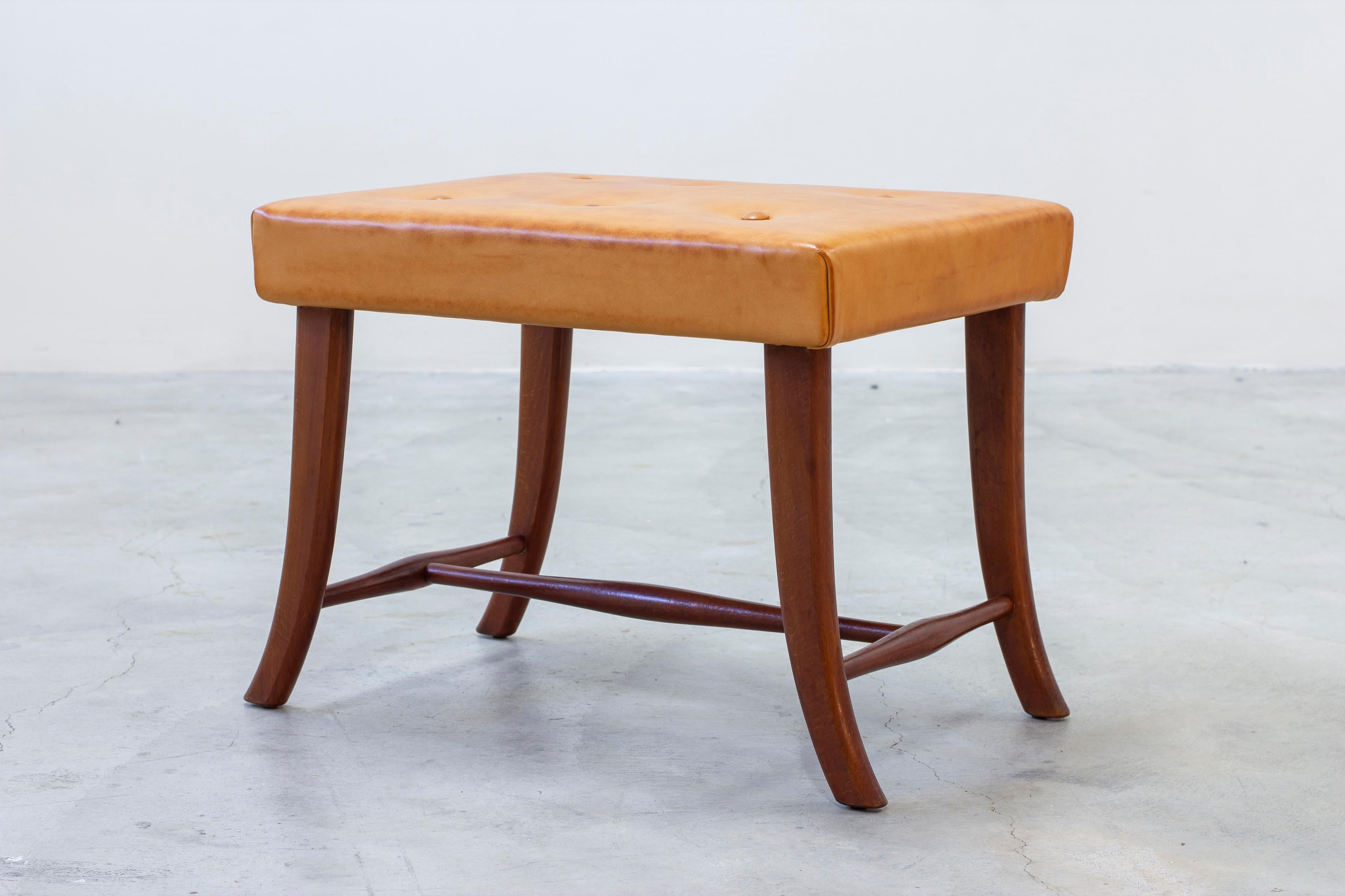 Tabouret en cuir et acajou à la manière de Josef Frank. Fabriqué par un ébéniste inconnu. Pieds incurvés en acajou massif. Assise recouverte d'un cuir de couleur cognac. Très bon état vintage avec une légère usure liée à l'âge et une patine du