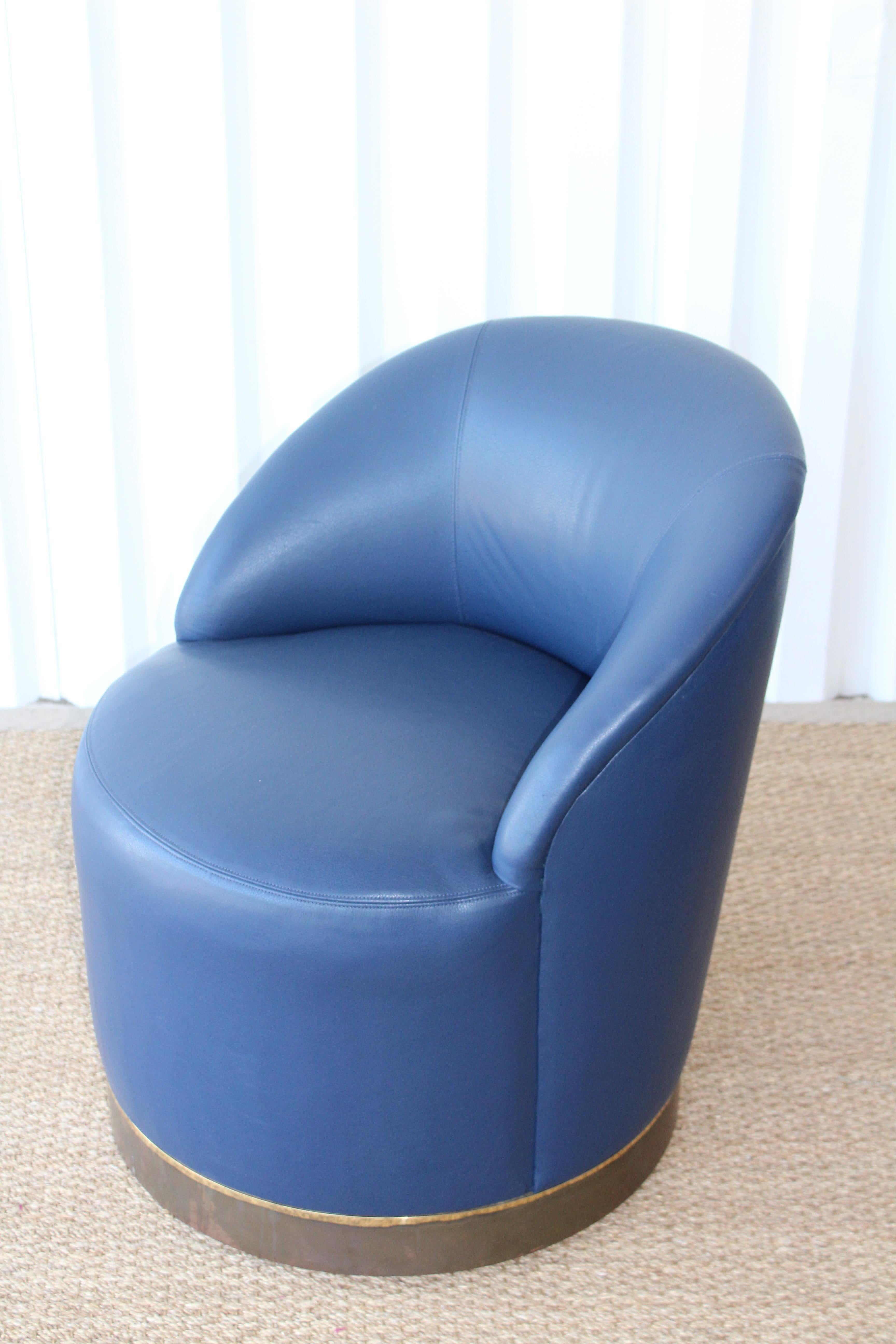 Vintage 1970s swivel chairs designed by Karl Springer. Each chair has been reupholstered in a beautiful navy blue leather. Each chair has a brass trim which shows age appropriate patina. Price is per chair. Three available, sold individually.