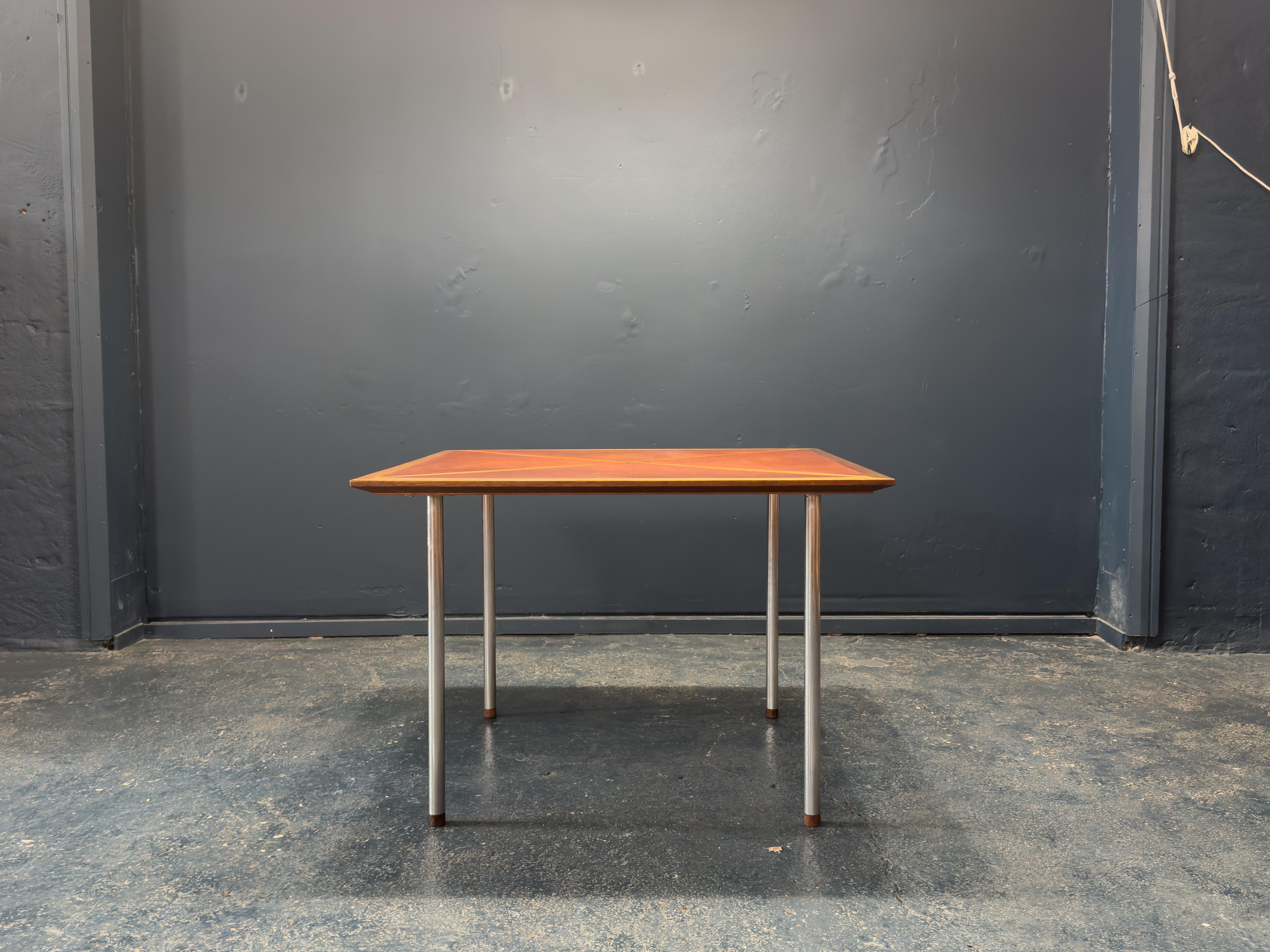 Cette table élégante associe des matériaux raffinés à une forme minimaliste, avec un plateau recouvert de cuir riche posé sur des pieds métalliques élégants. La surface est recouverte d'un cuir chaud et texturé qui confère à la fois un intérêt