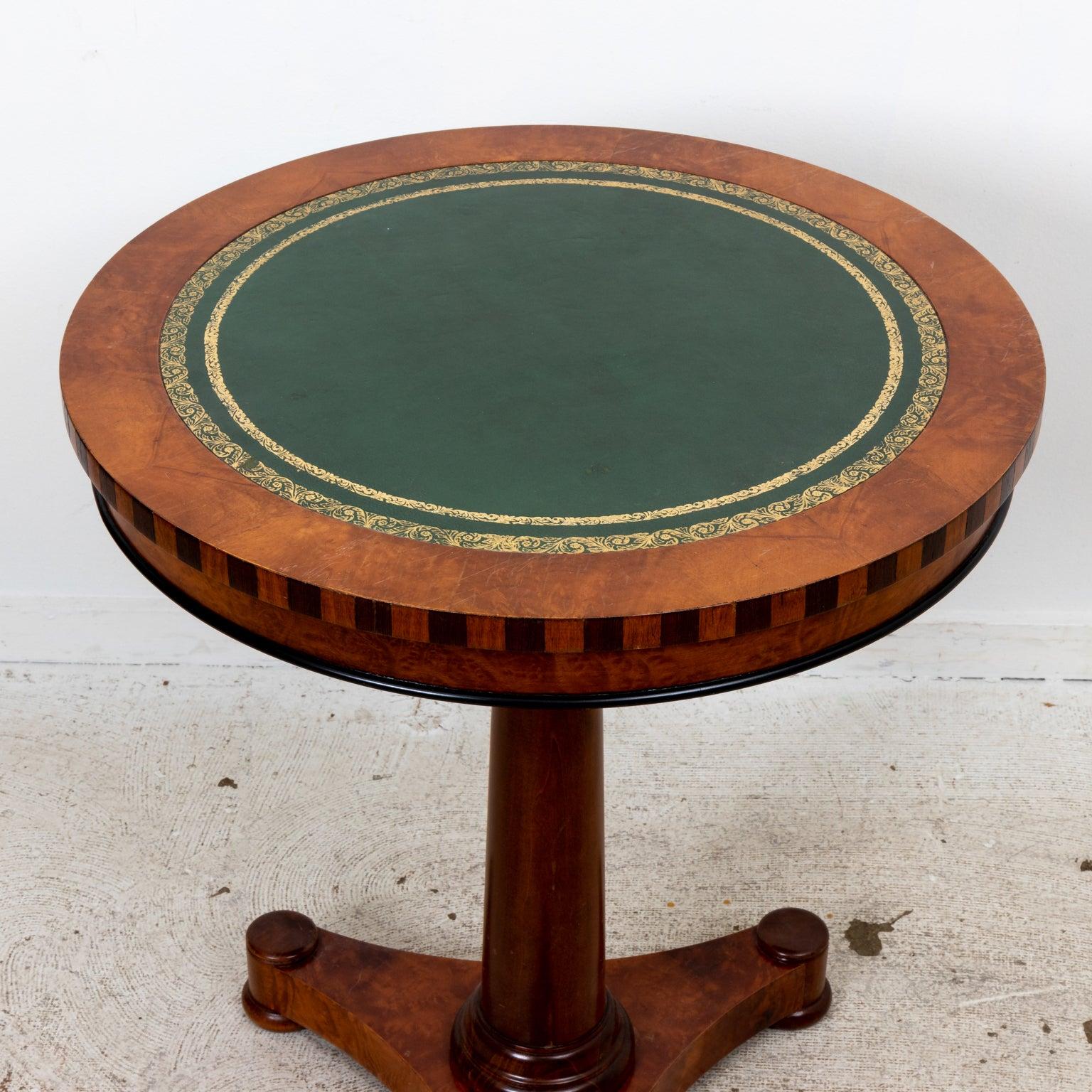 Small green leather topped pedestal side table. Made in USA. Made in last quarter of 20th century. Please note wear consistent with age.
 