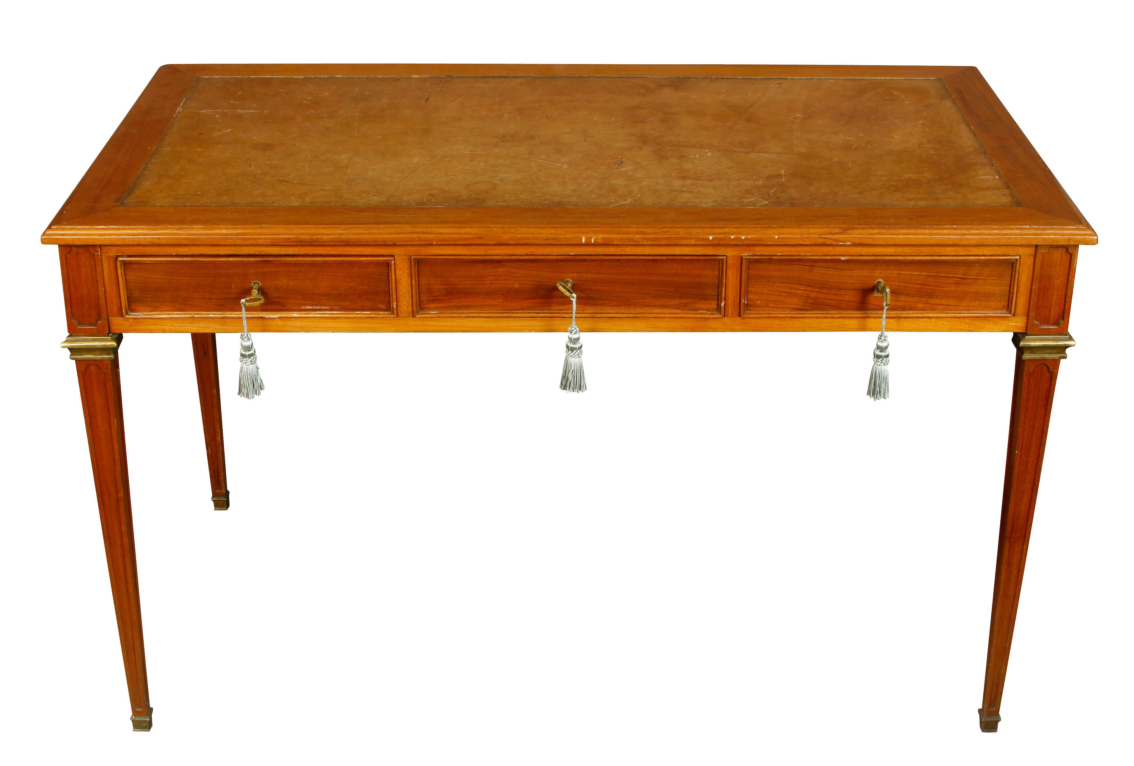 Leather top Louis XVI style writing desk with brass trim and three drawers.