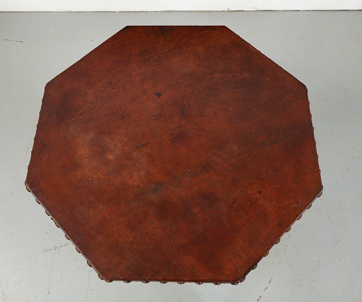 Une importante table centrale Arts & Crafts avec un plateau octogonal recouvert de cuir avec des bords cloutés, reposant sur quatre pieds carrés effilés reliés par un étrier en X. Américain, vers 1900.