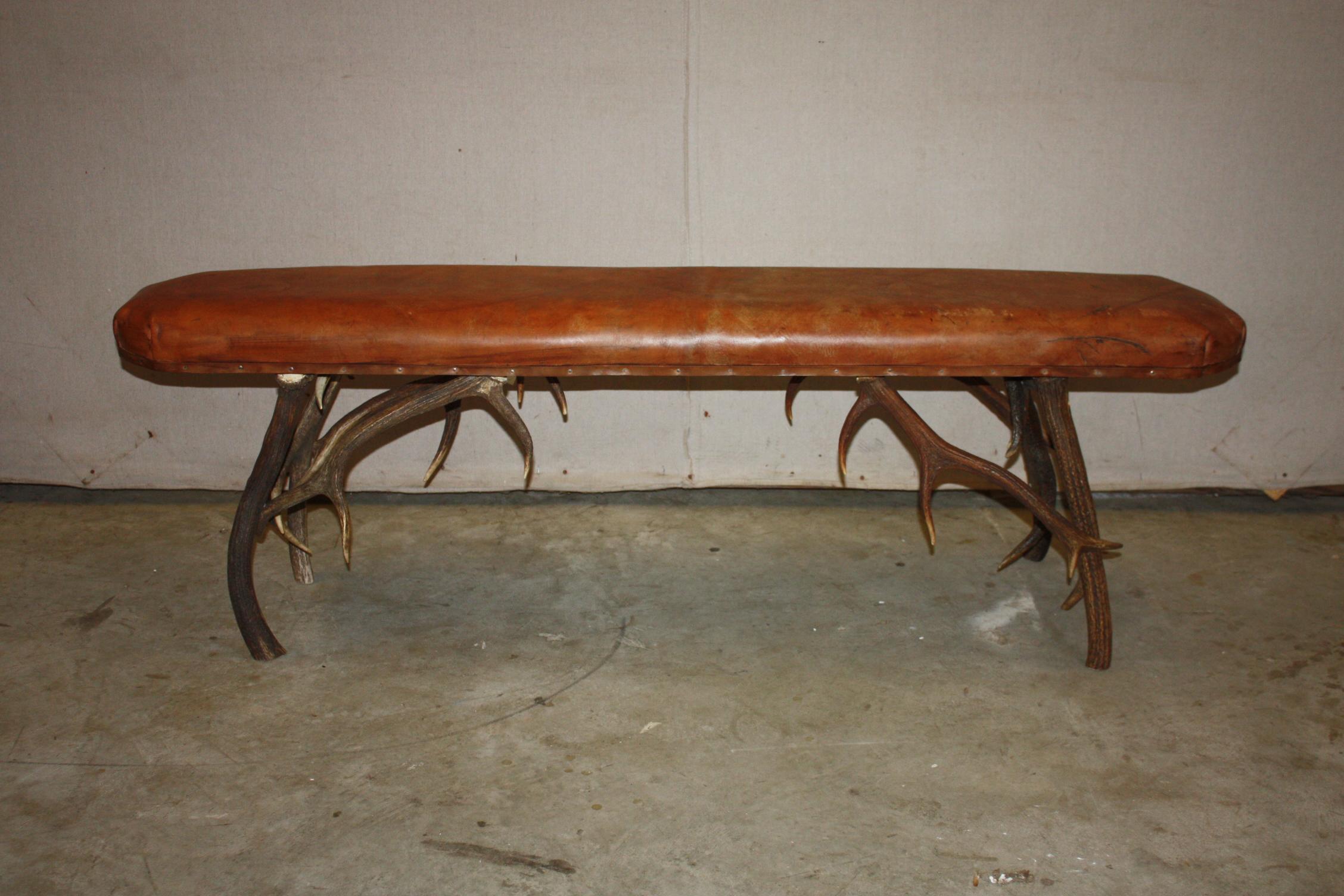 This is a great looking stag horn leather top bench I purchased in England. The leather is a nice worn saddle color. There is wear on the leather.