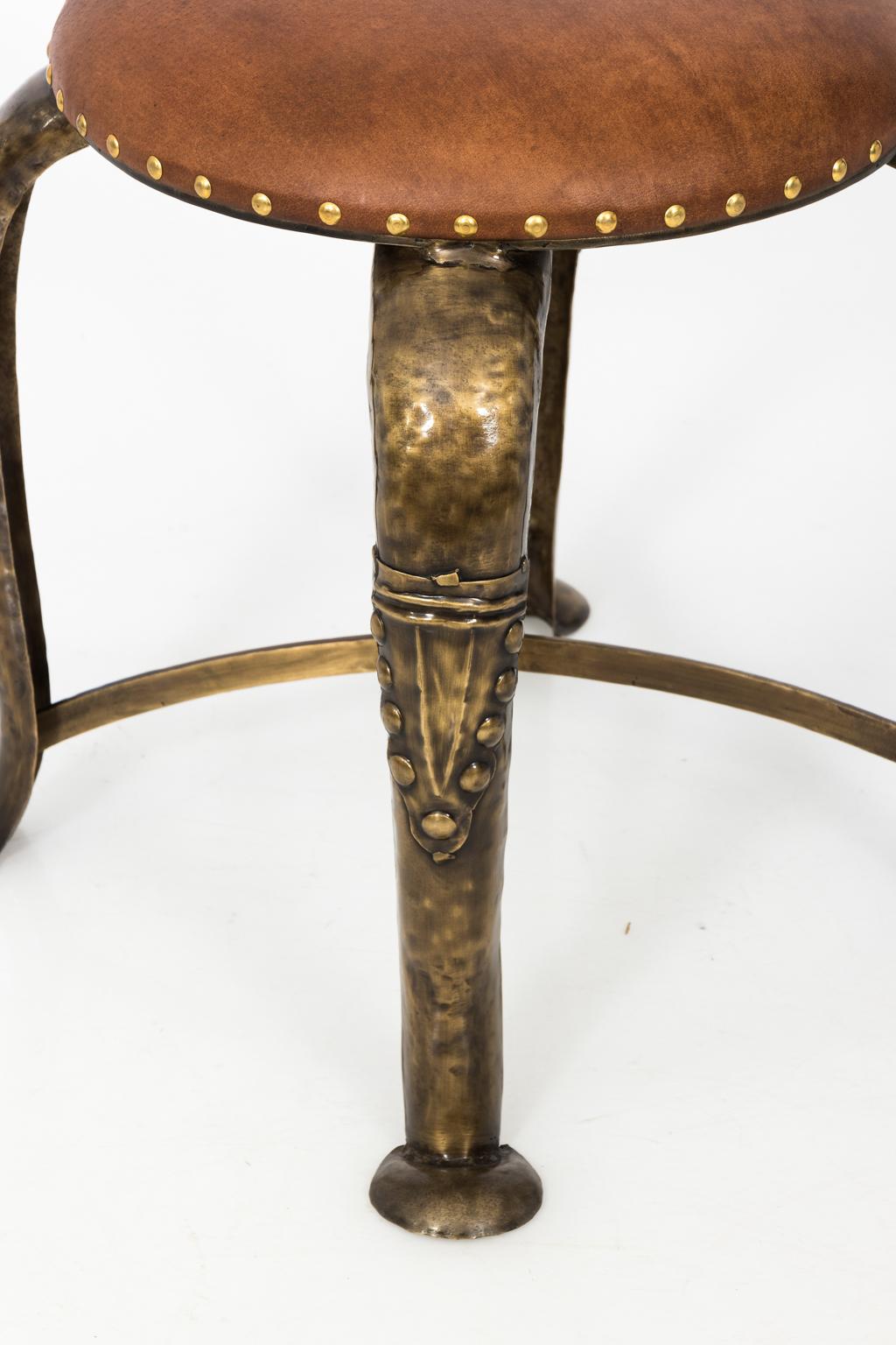 Leather top stool on metal base in brass antiqued finish.