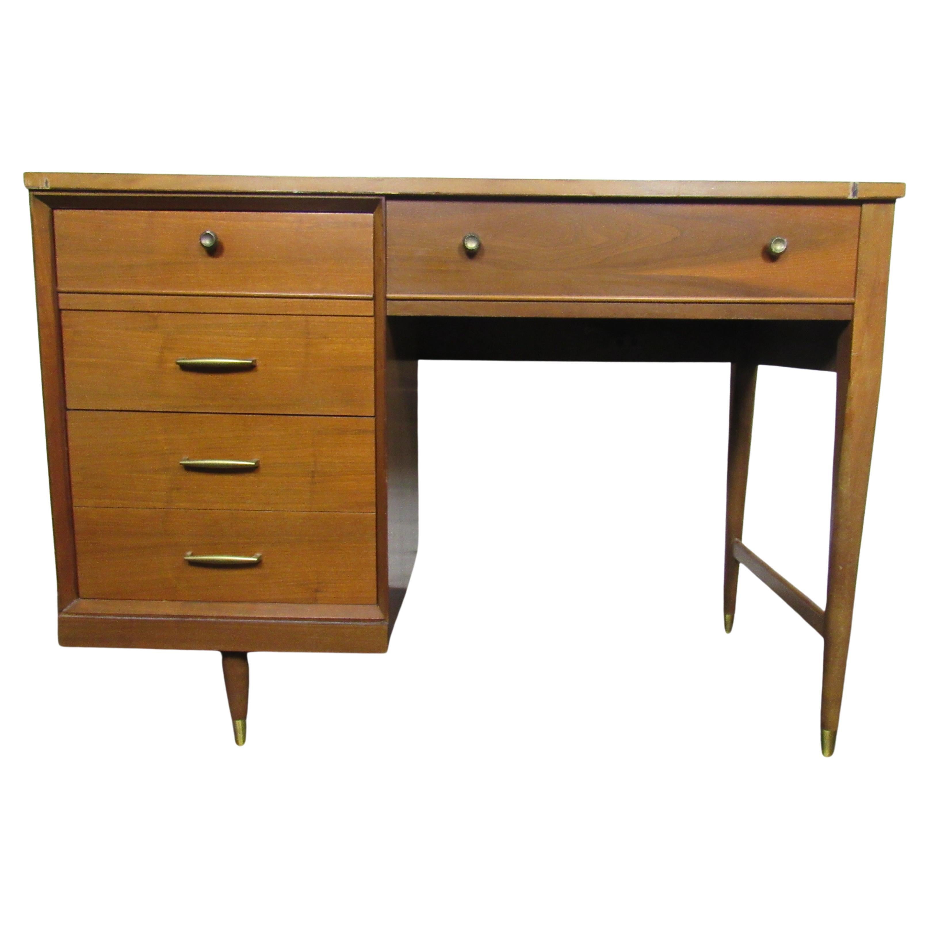 This vintage writing desk includes a protective cover for part of the top surface, multiple drawers for storage, and brass accents. Please confirm item location with seller (NY/NJ).