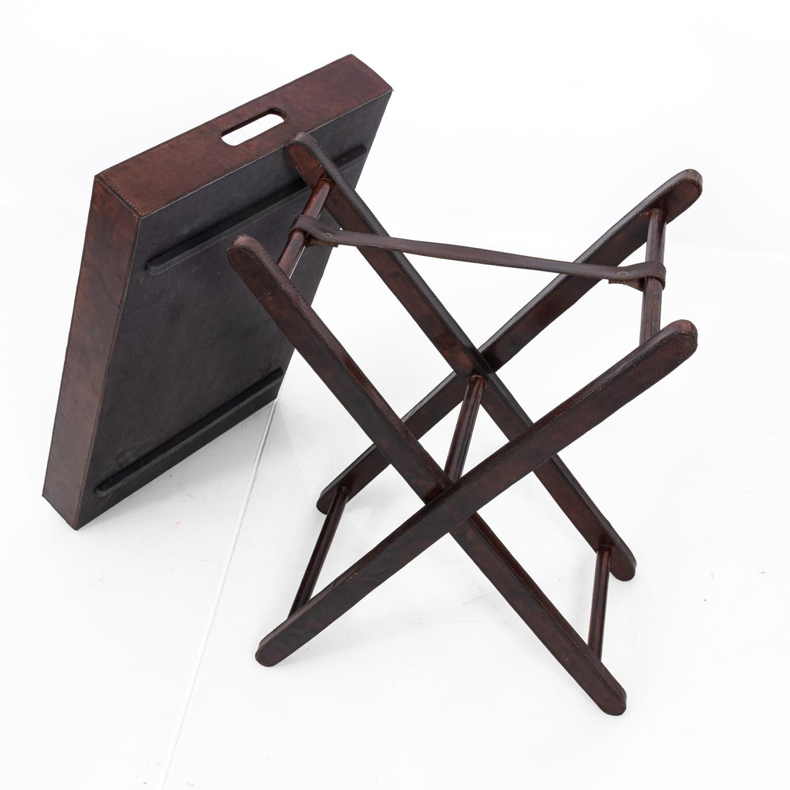 Leather tray table on folding leather base. Weight: Under 40 LBS. Minor wear to tray.