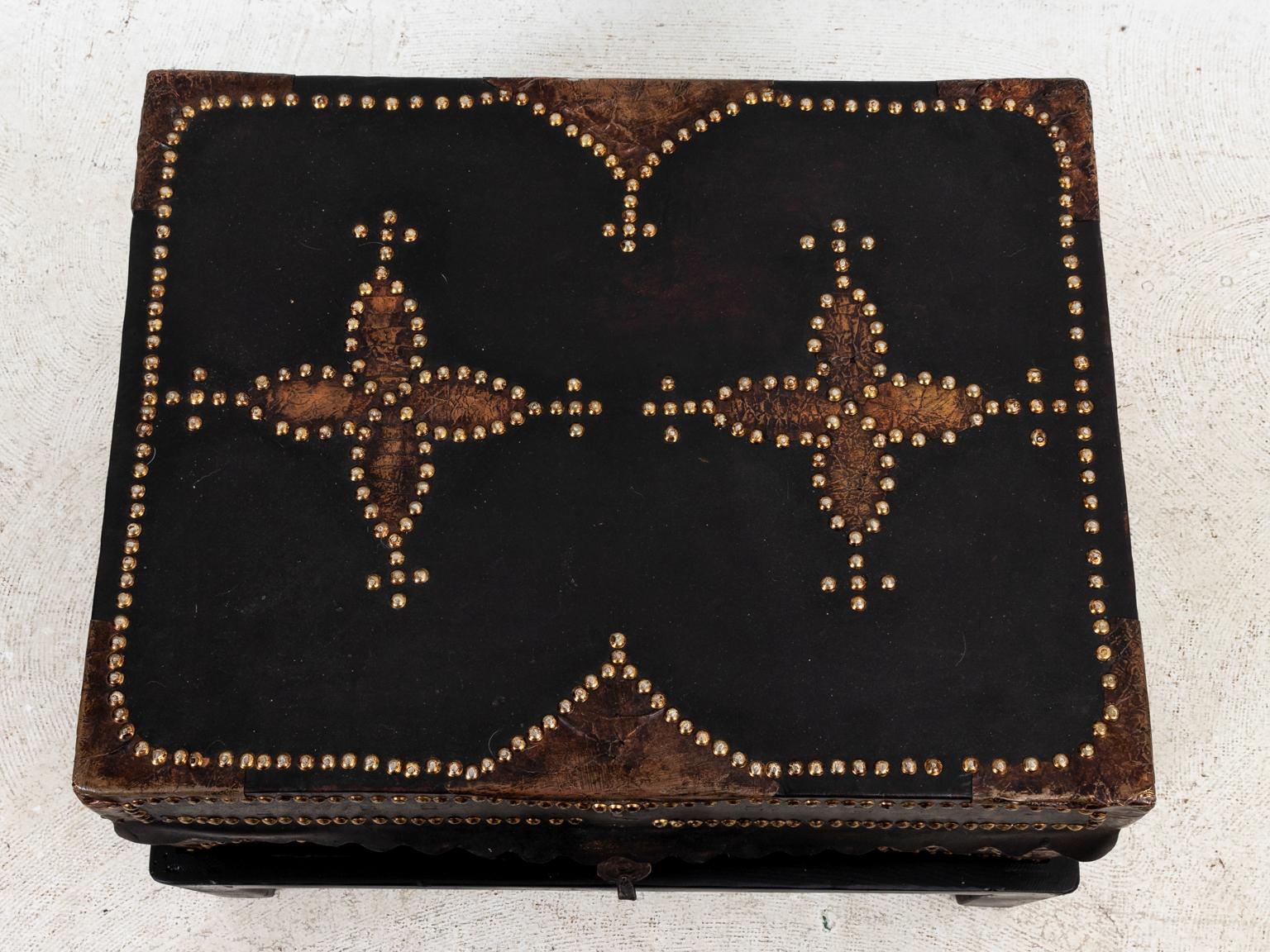 Black leather trunk on stand with brass tacks, circa 19th century. Made in Spain. Please note of wear consistent with age including distressed finish to the leather, patina to metal handles, and minor scratches on the bottom stand.