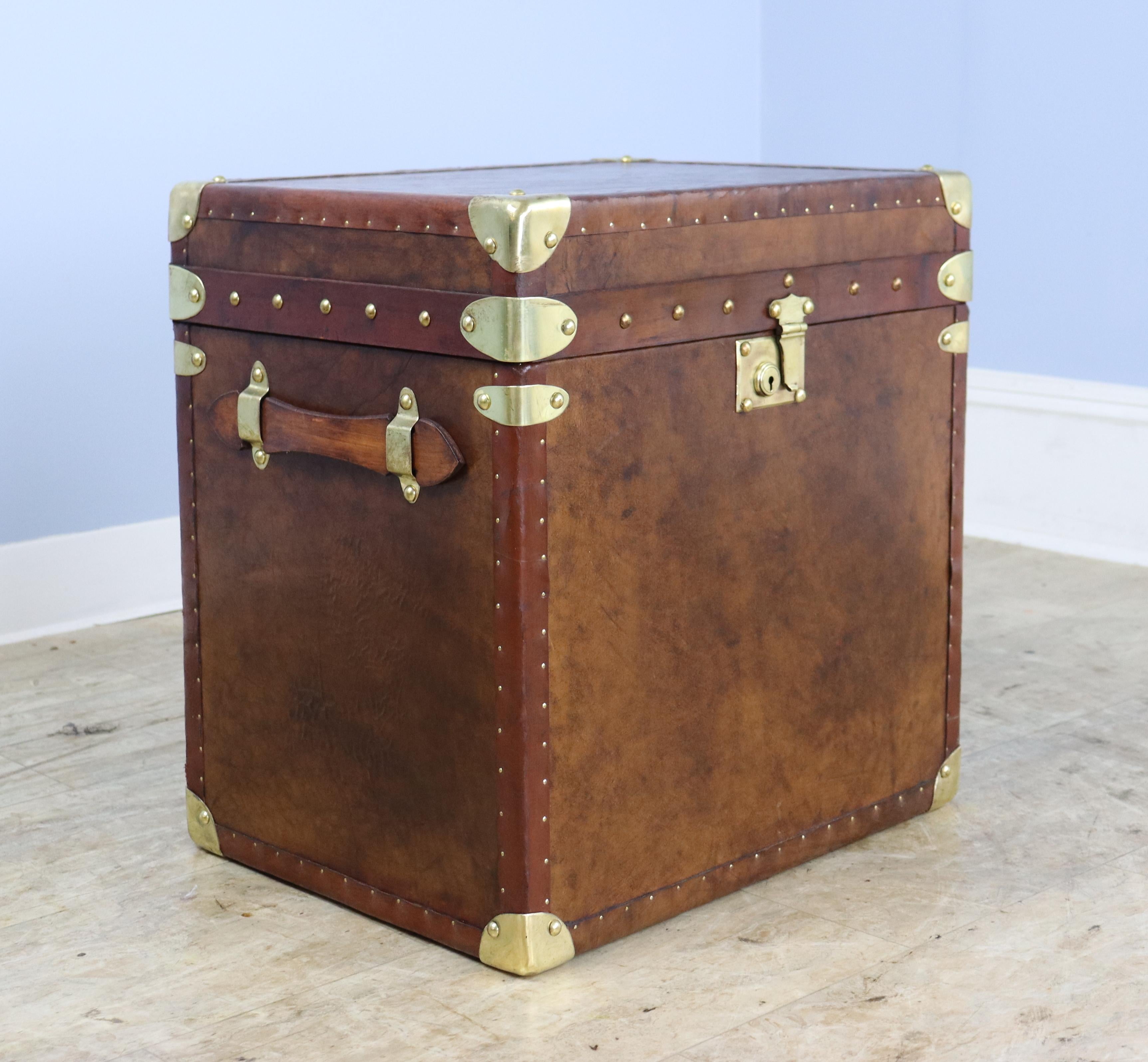 A handsome leather trunk, newly made from new leather with vintage leather trim, as we well as vintage brass detail and locks.  New dark blue fabric interior is clean and complements the look of the exterior.  Great for storage but also would make a
