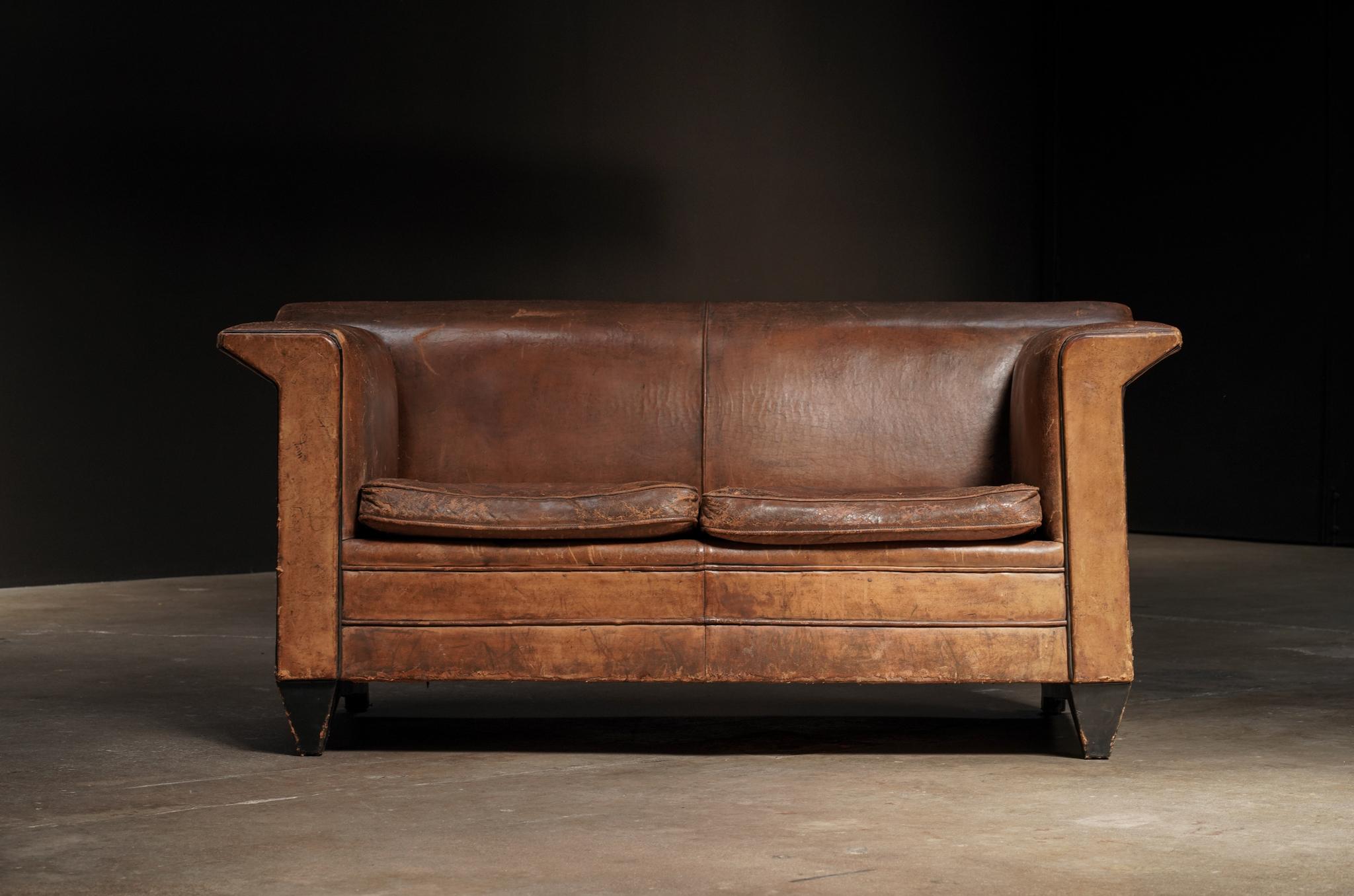 A mid-20th century two-seater by Dutch designer Bart Van Bekhoven, defined by angular lines and sculptural presence. Upholstered in richly patinated brown leather that highlights its bold, architectural form.