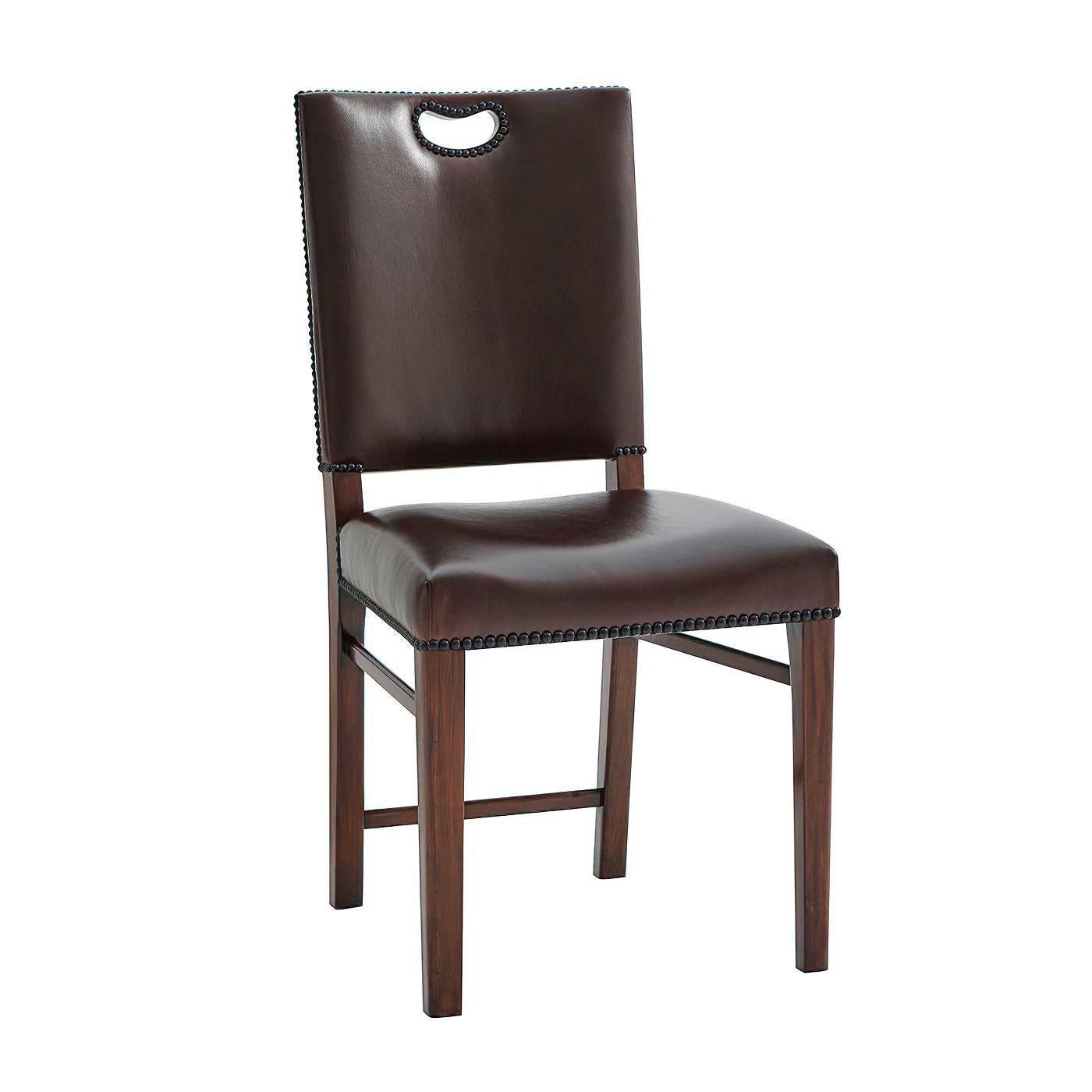A Campaign side chair, the padded rectangular back with a pierced carrying handle above an upholstered seat on square tapering legs joined by stretchers. Inspired by a 19th century English original.

Dimensions: 19