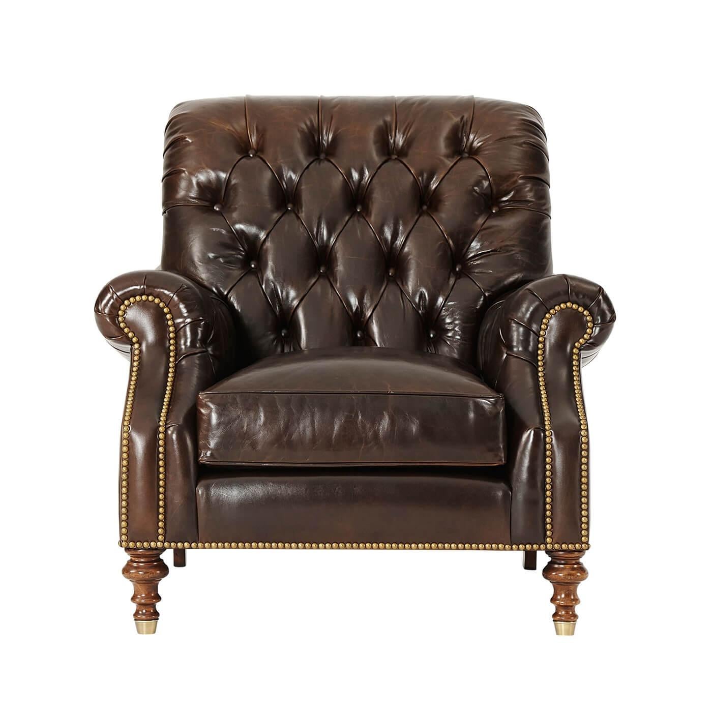 A British style leather-upholstered armchair, the tufted scroll over back above a cushioned seat, enclosed by tufted roll arms, on turned legs with brass cappings. Inspired by a Victorian original.

Dimensions: 38