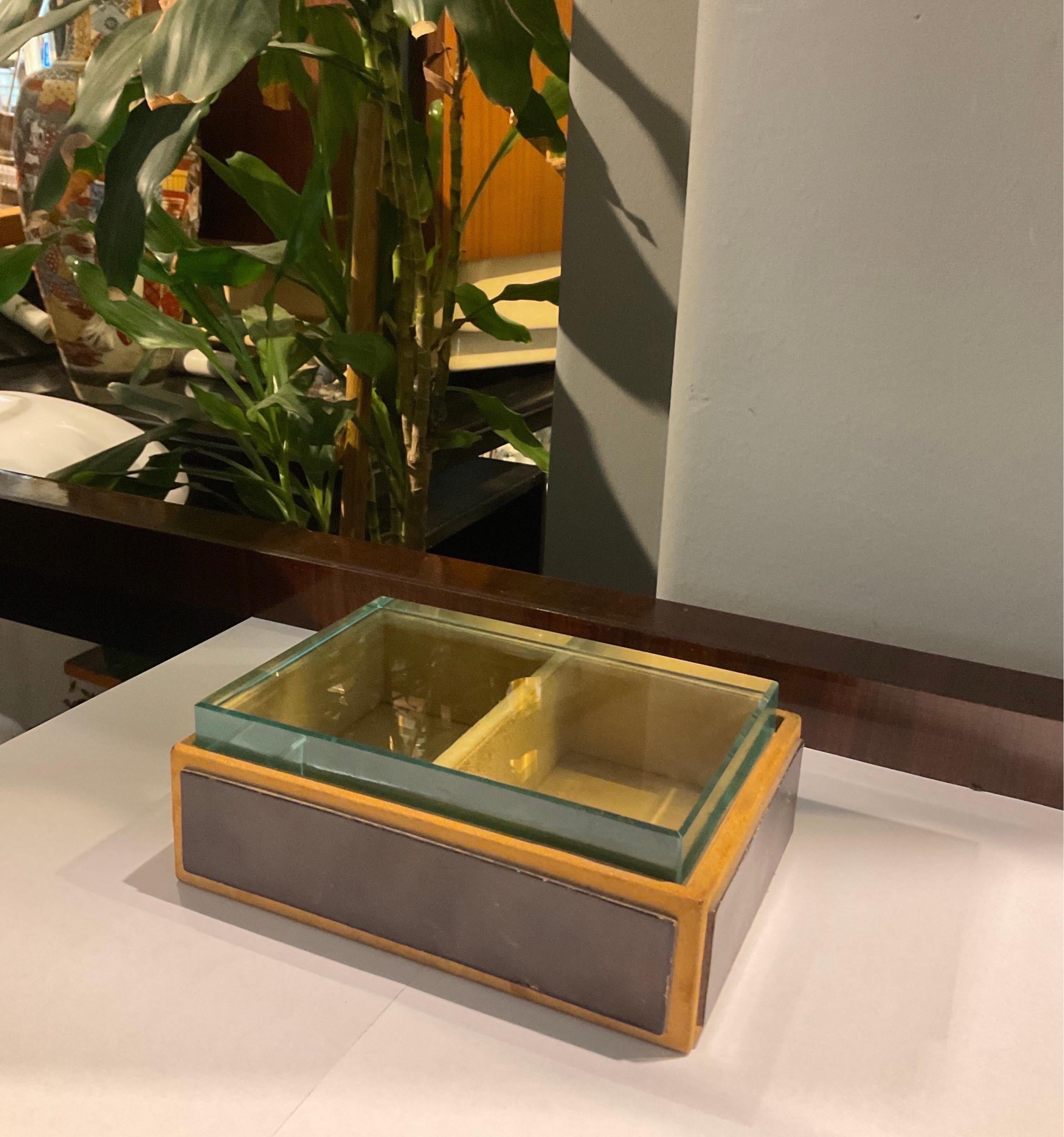 Magnificent rectangular shaped wooden jewellery box covered with leather, topped by a Nile green glass plate that gives perfect visibility from the outside to the inside of the box. It is attributable to the famous Italian designer Pietro Chiesa in
