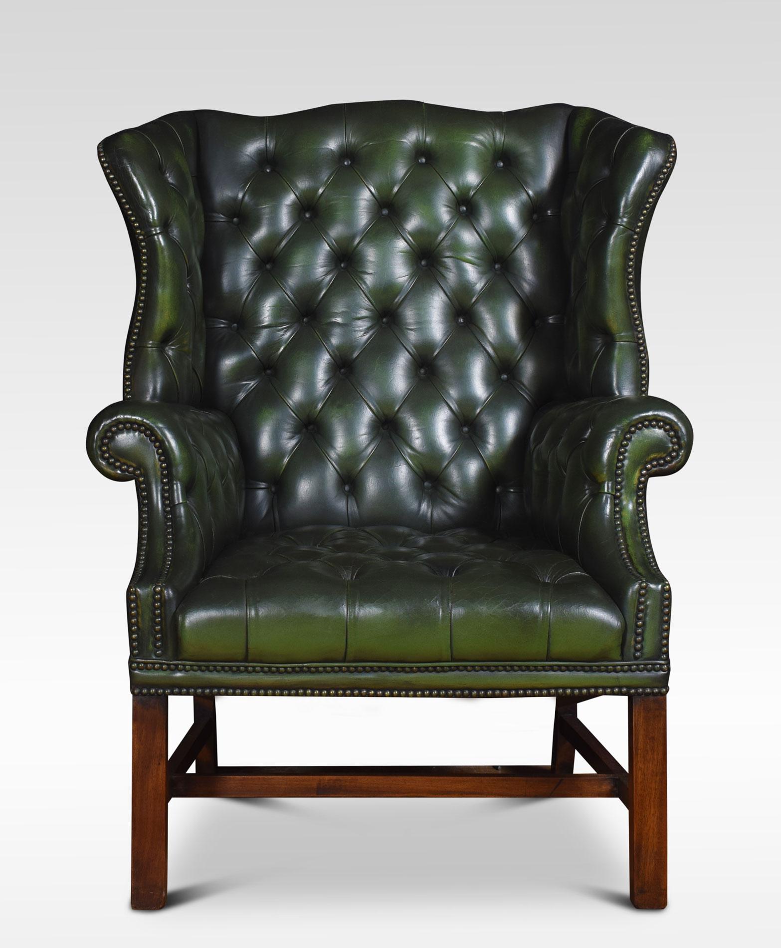 Mahogany framed wing armchair of generous proportions, the arched top above deep buttoned back, upholstered arms and seat in green leather, raised up on square supports united by a stretcher.
Dimensions:
Height 44 inches height to seat 17