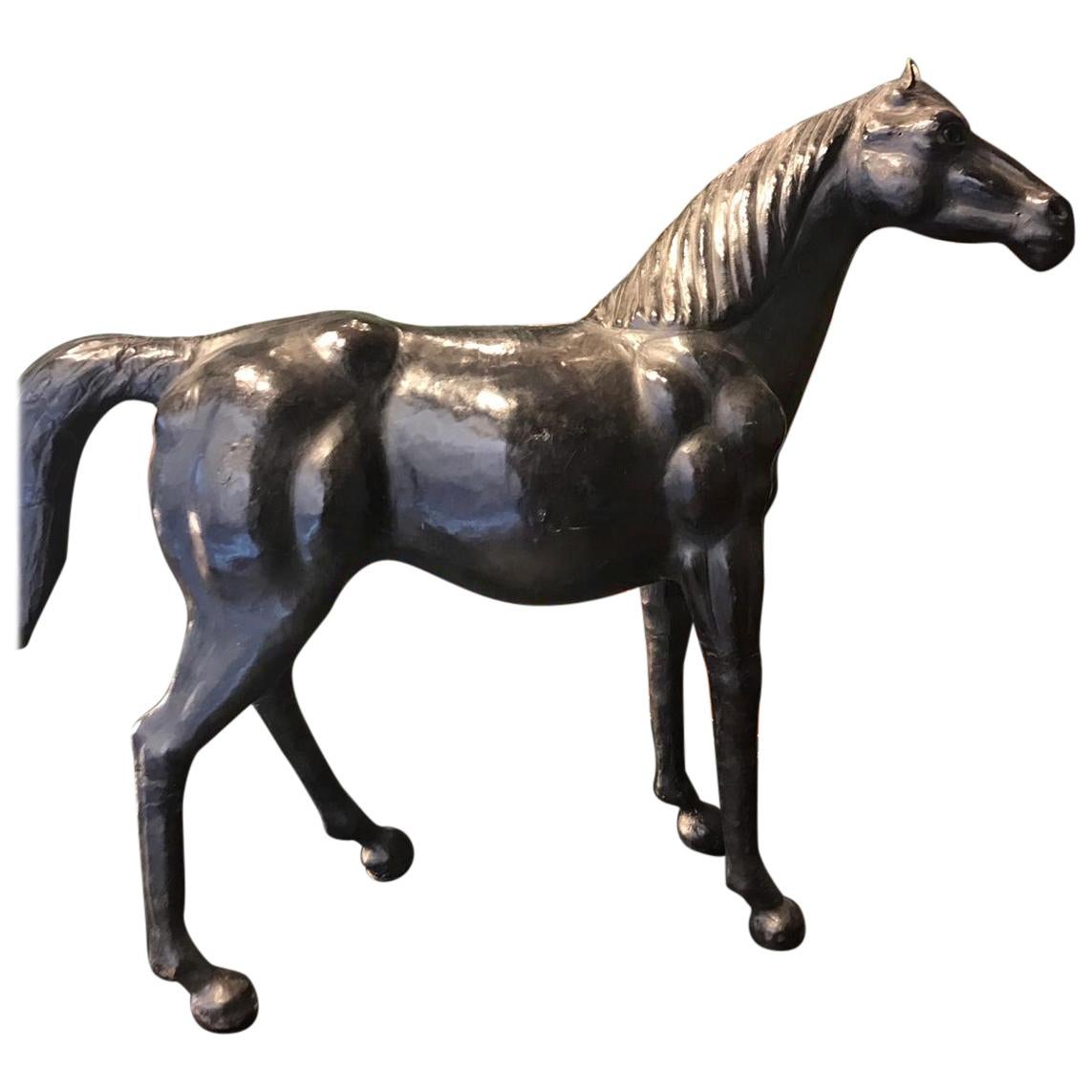 A medium seized vintage sculpture representing a horse clad in dark brown leather, with glass eyes. From Italy, from mid-20th century. It is in excellent vintage conditions with age appropriate patina. We have done only a conservative restoration