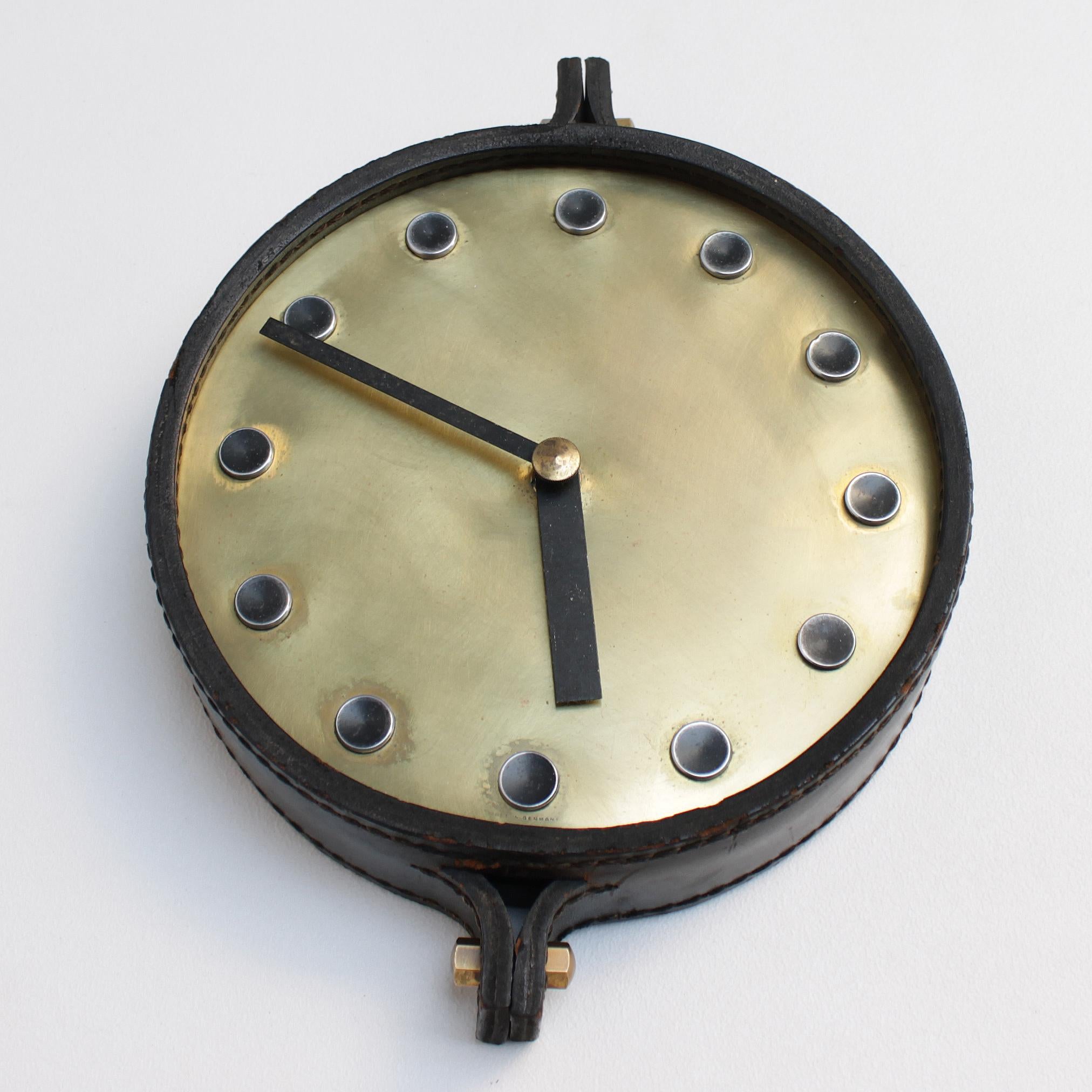 This decorative wall clock resembles a couple of designs by Carl Auböck, but was most likely manufactured by Junghans: the well known German company which also executed the timepieces of Max Bill.
The clock has a steel base and an anodised aluminum