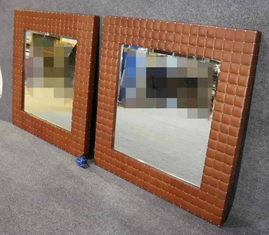 Pair of wall mirrors with beveled glass and leather frames. Leather tufted with exposed nail heads.
Please confirm location.