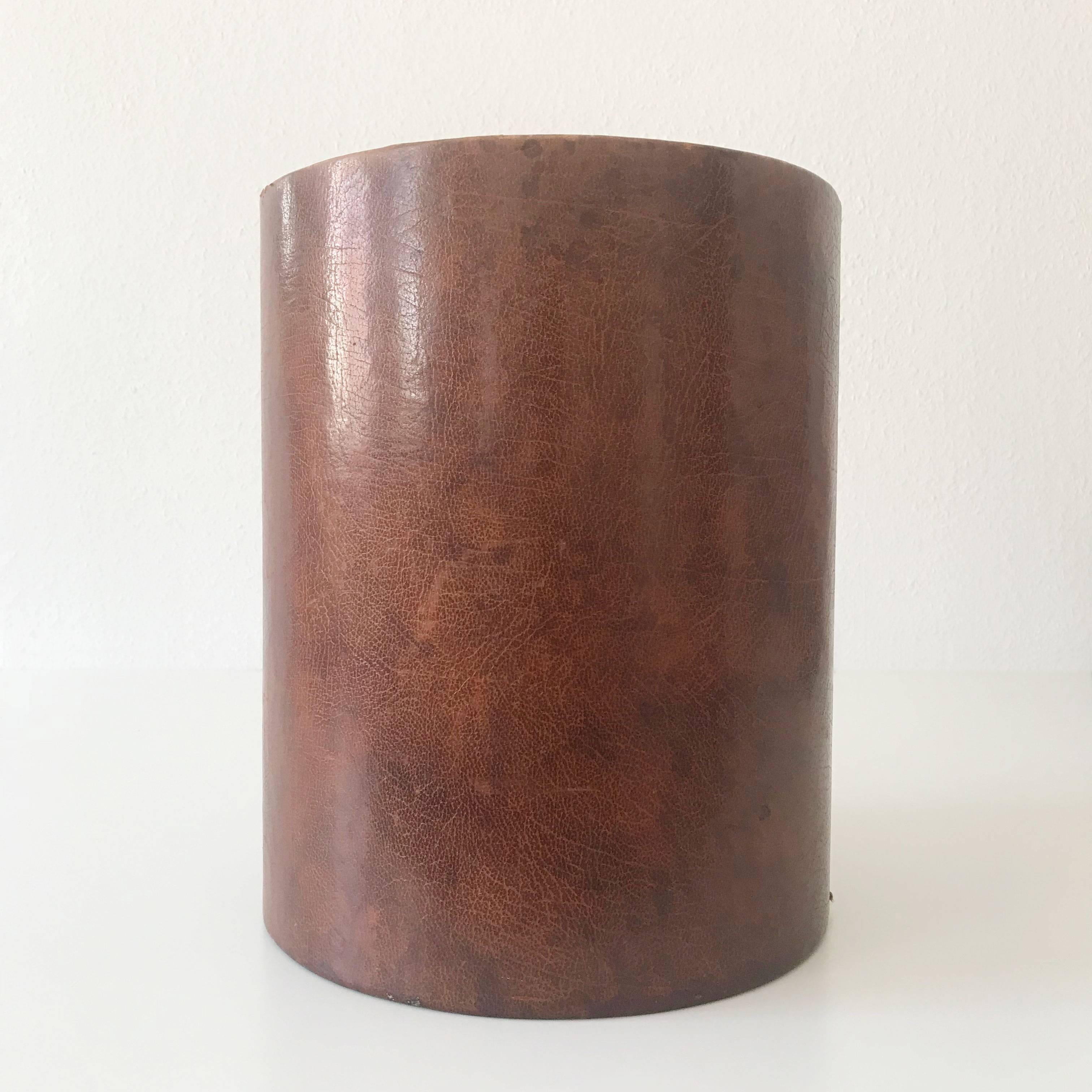 Elegant Mid-Century Modern waste paper basket in the style of Carl Auböck.
It is executed in dark brown leather and has a nice patina.

Wear consistent with use and age. Water mark on one side (please look at the images).