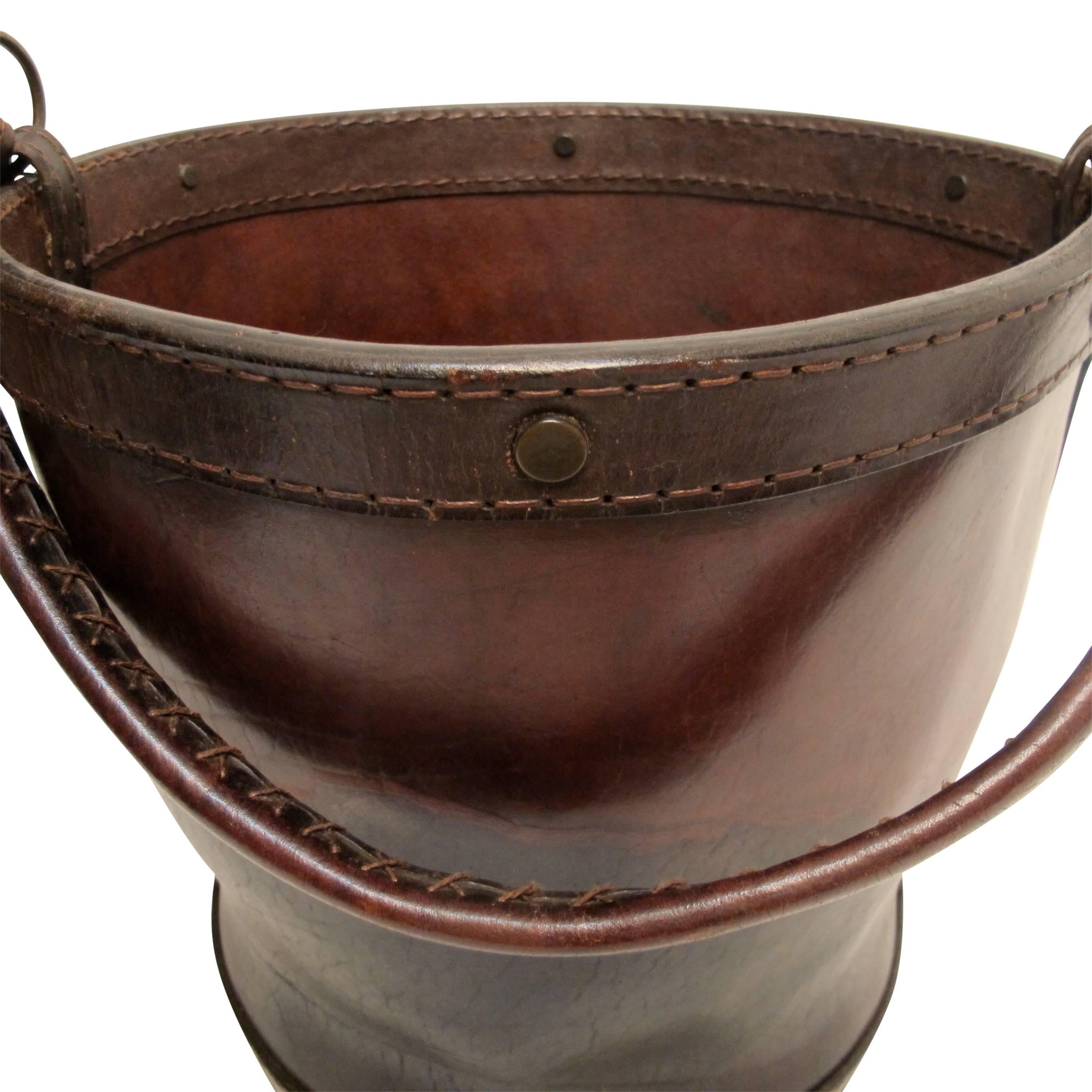 A large dark brown leather water or feed bucket, England, late 19th century.
Would make a handsome waste basket or used next to the fireplace.