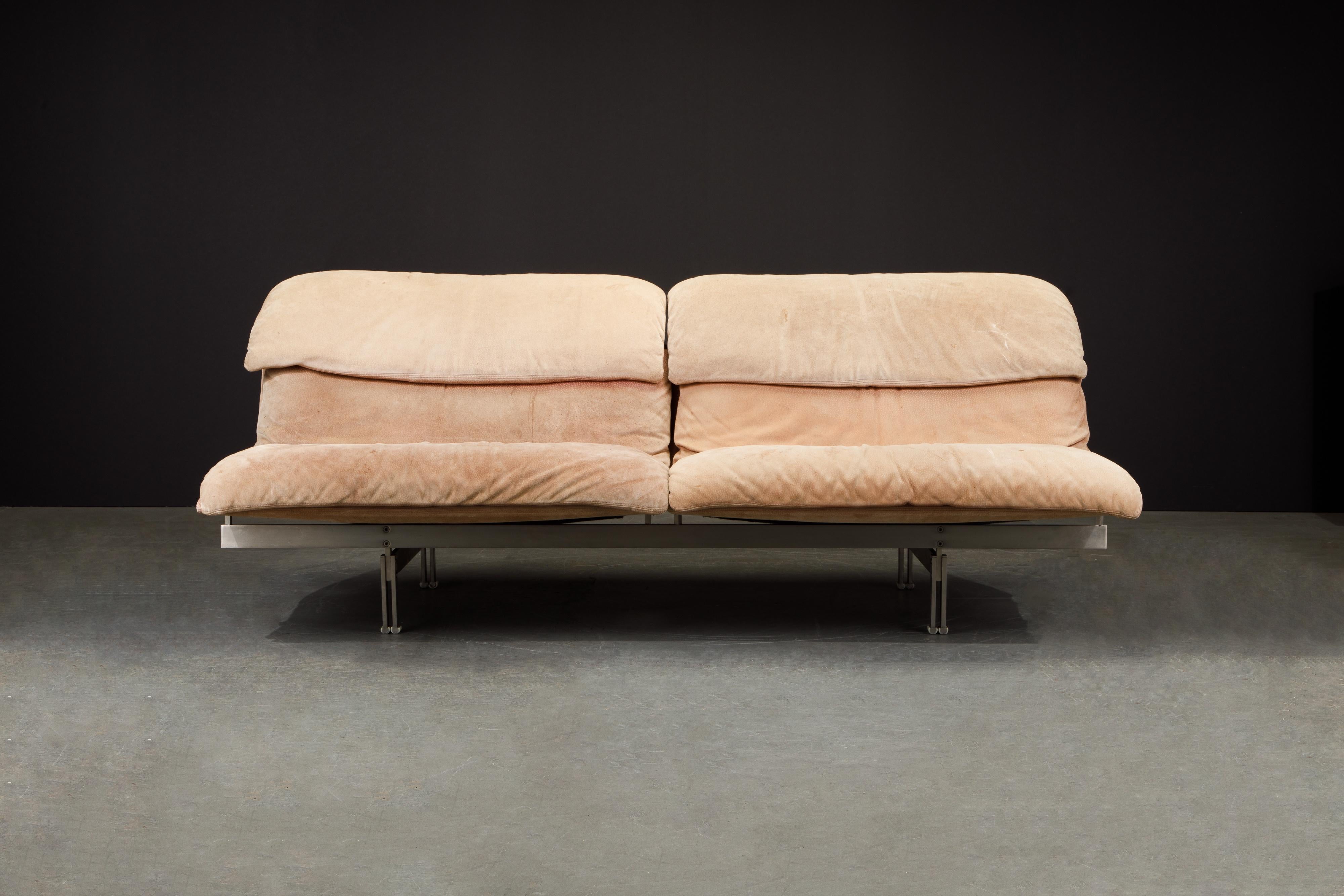 This gorgeous 'Wave' loveseat was designed by Giovanni Offredi for Saporiti Italia in 1974 and features a hefty brushed stainless steel base with suede upholstery. The suede color is tan-brown with a bit of a peachy undertone, and has moderate