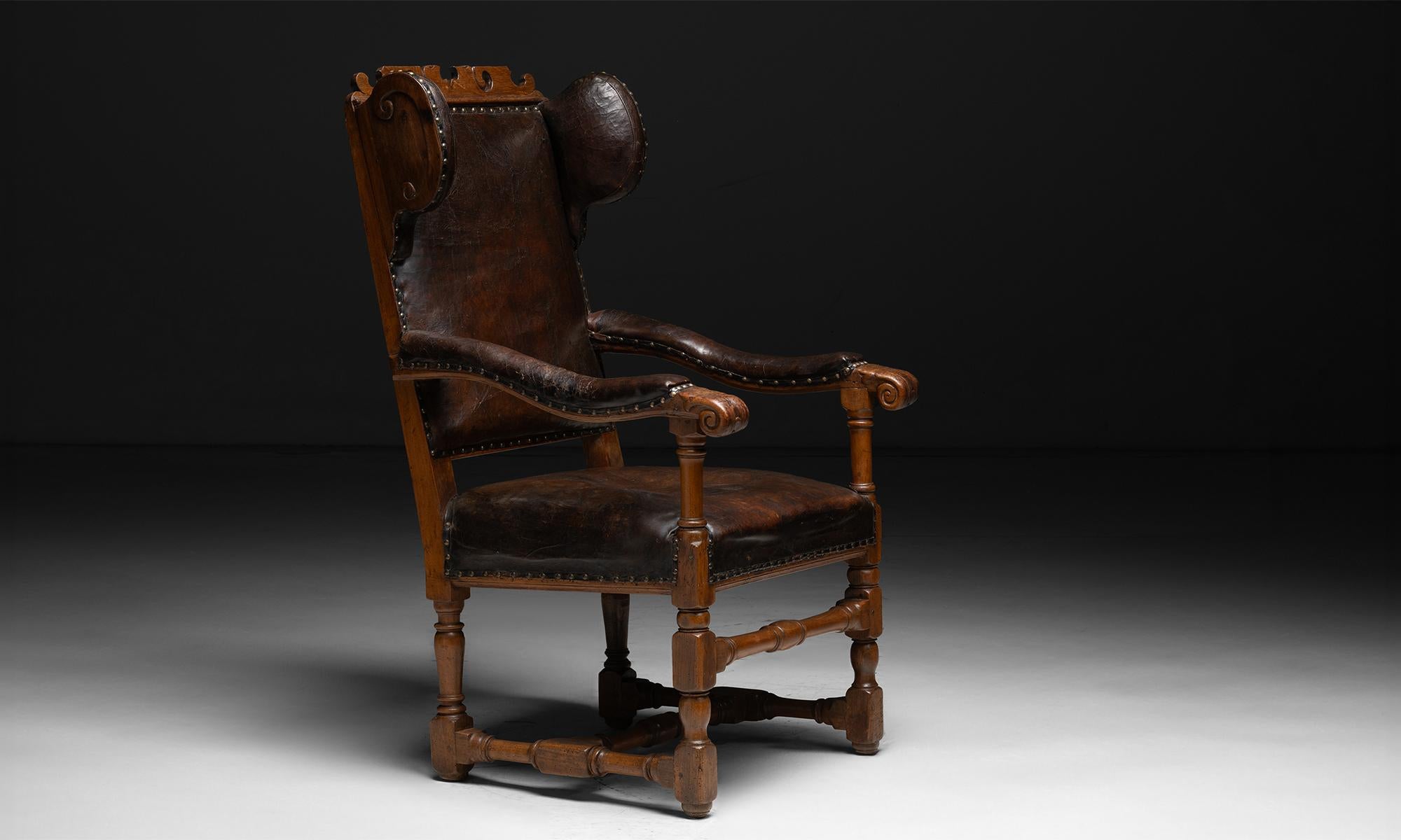 Leather Wingback Armchair

England, 1747

Wingback armchair with frame composed of elm and leather cushions. Brass rivets on surround of fabric, intricately carved balusters, and dated 