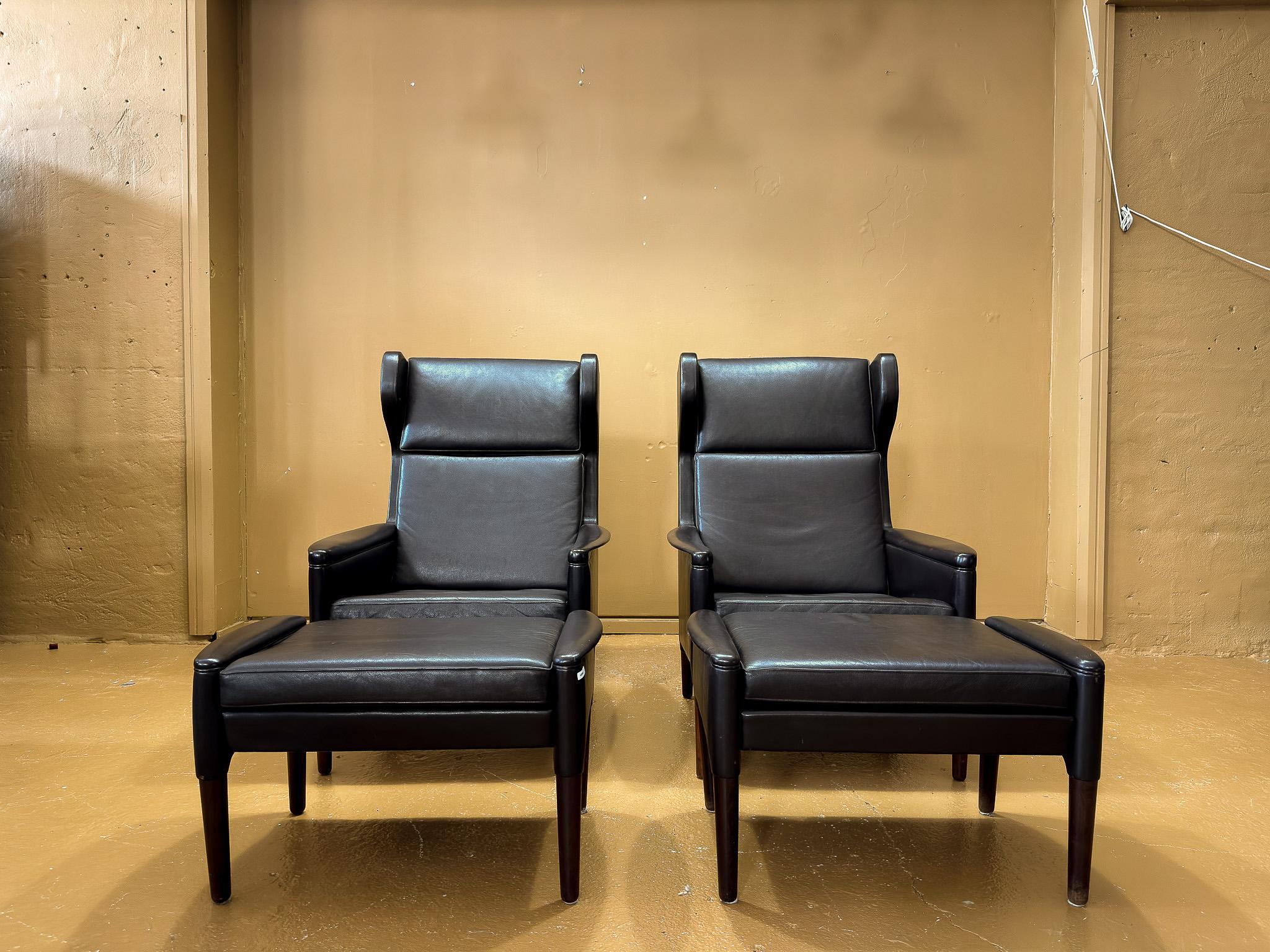 Cet élégant ensemble de fauteuils danois du milieu du siècle et de tabourets assortis incarne le savoir-faire artisanal et le design intemporel. Revêtues d'un luxueux cuir noir, ces chaises allient lignes épurées, confort ergonomique et matériaux de
