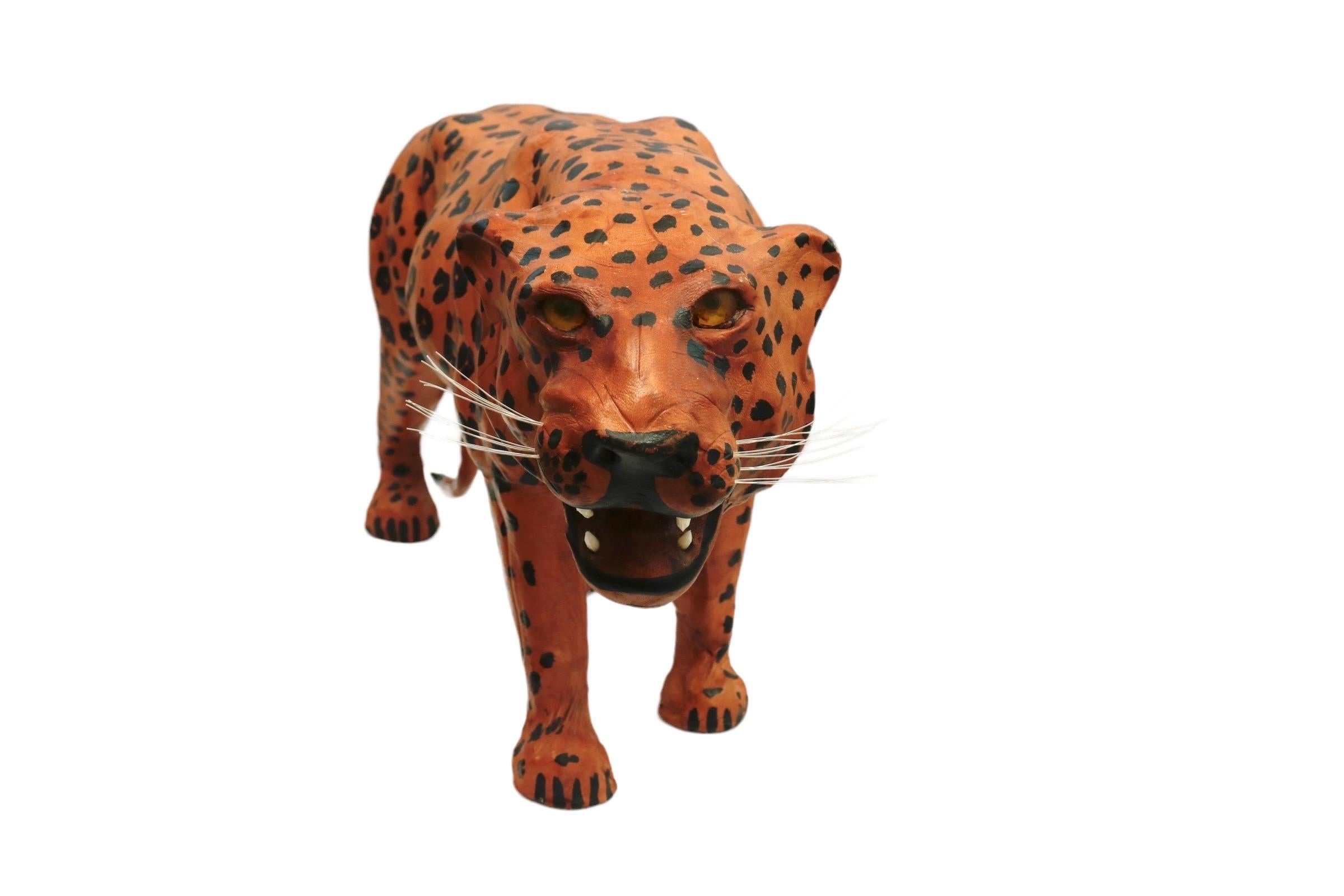 Escultura de leopardo envuelta en cuero, hacia 1960. Pintado a mano con manchas negras sobre un cuerpo naranja. Los detalles de la cara incluyen bigotes de nailon, ojos y dientes de resina. 