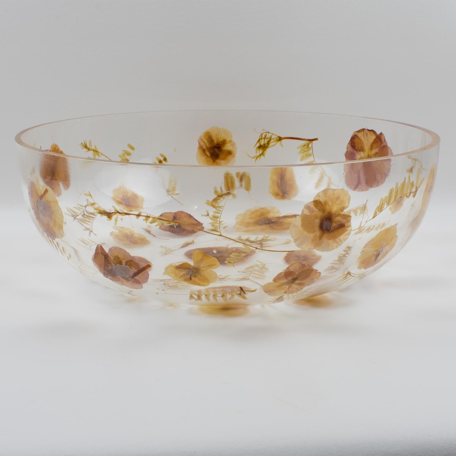 Resinplast, Italia, diseñó y fabricó este impresionante cuenco o centro de mesa decorativo de resina hacia 1970. El cuenco de resina o acrílico transparente, extragrueso y redondeado, tiene hojas de otoño y flores secas incrustadas. La coloración