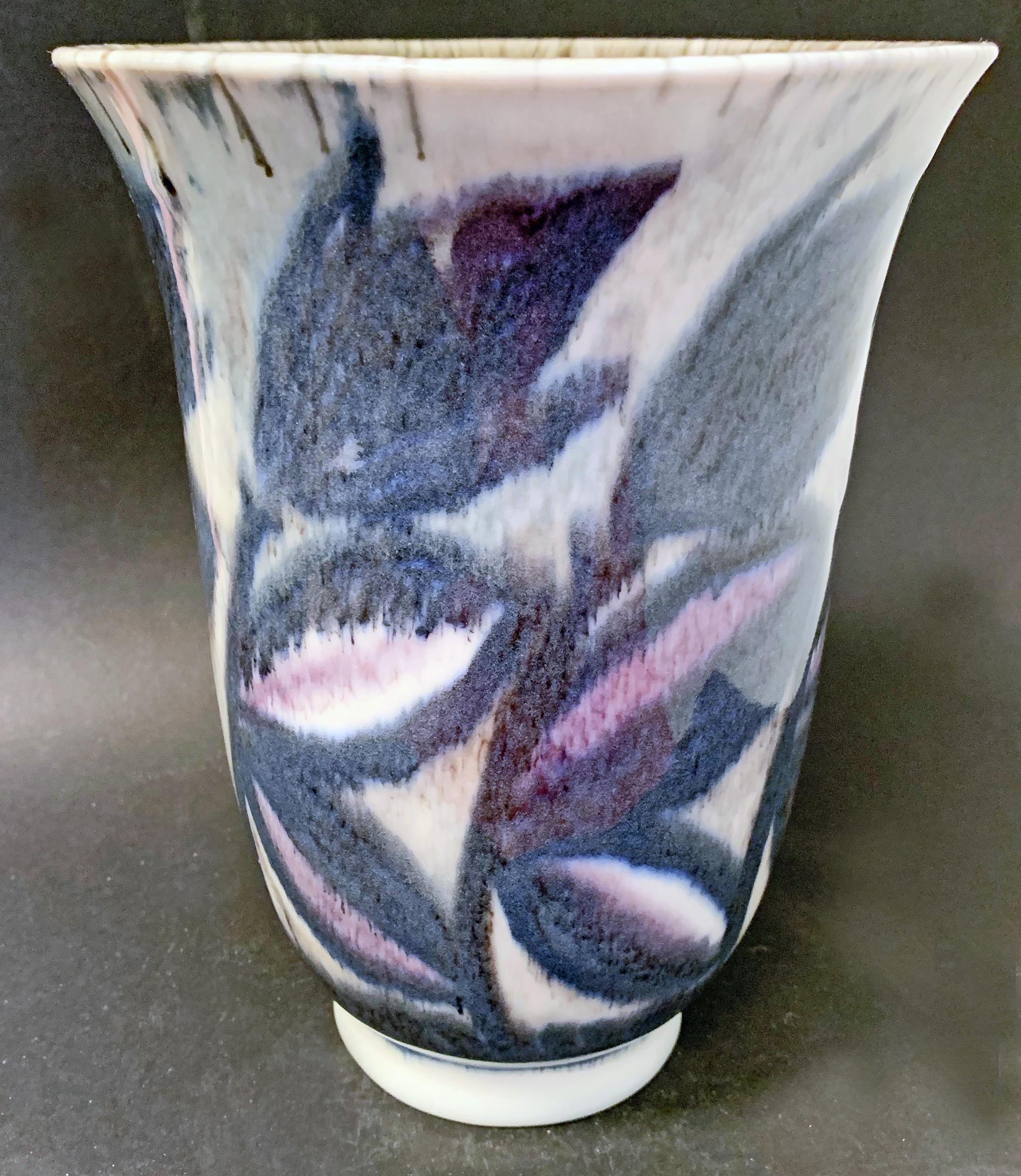 Equal to the finest Art Deco vases produced in France in the 1930s, this flaring vase is covered in large flowers and leaves in charcoal and deep rose, all in the suffused, dripping glazes perfected by William Hentschel, the artist. Hentschel was
