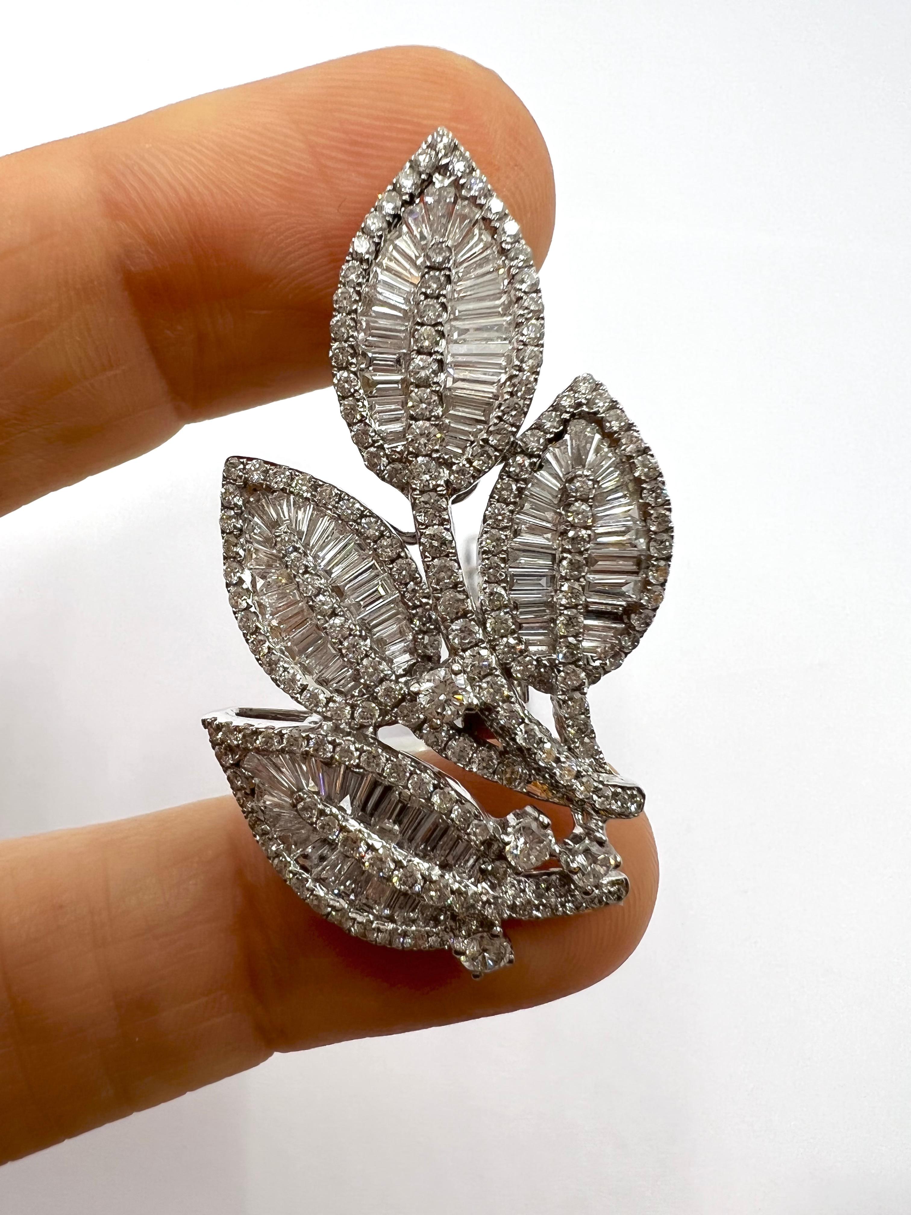 Beautiful pair of earrings representing a bouquet of 4 leaves in white gold paved with 6 carats of diamonds. Each of the 4 leaves has a long stem set with round diamonds, to give contrast and more sparkle the leaves are set in their center with