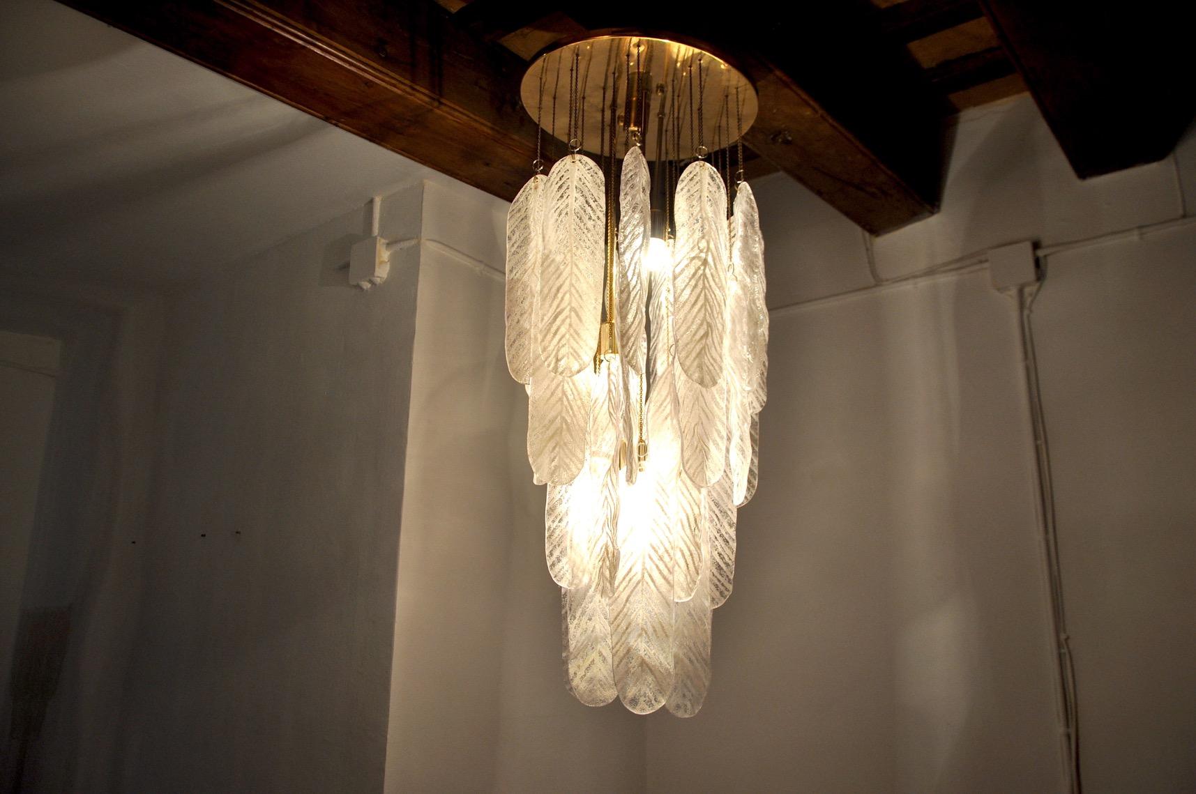 Superbe et rare lampe suspendue Murano conçue et produite à Murano, en Italie, dans les années 70. Ce magnifique lustre est composé de longues feuilles de verre blanc dépoli de Murano, suspendues en spirale à une structure en métal doré. Objet