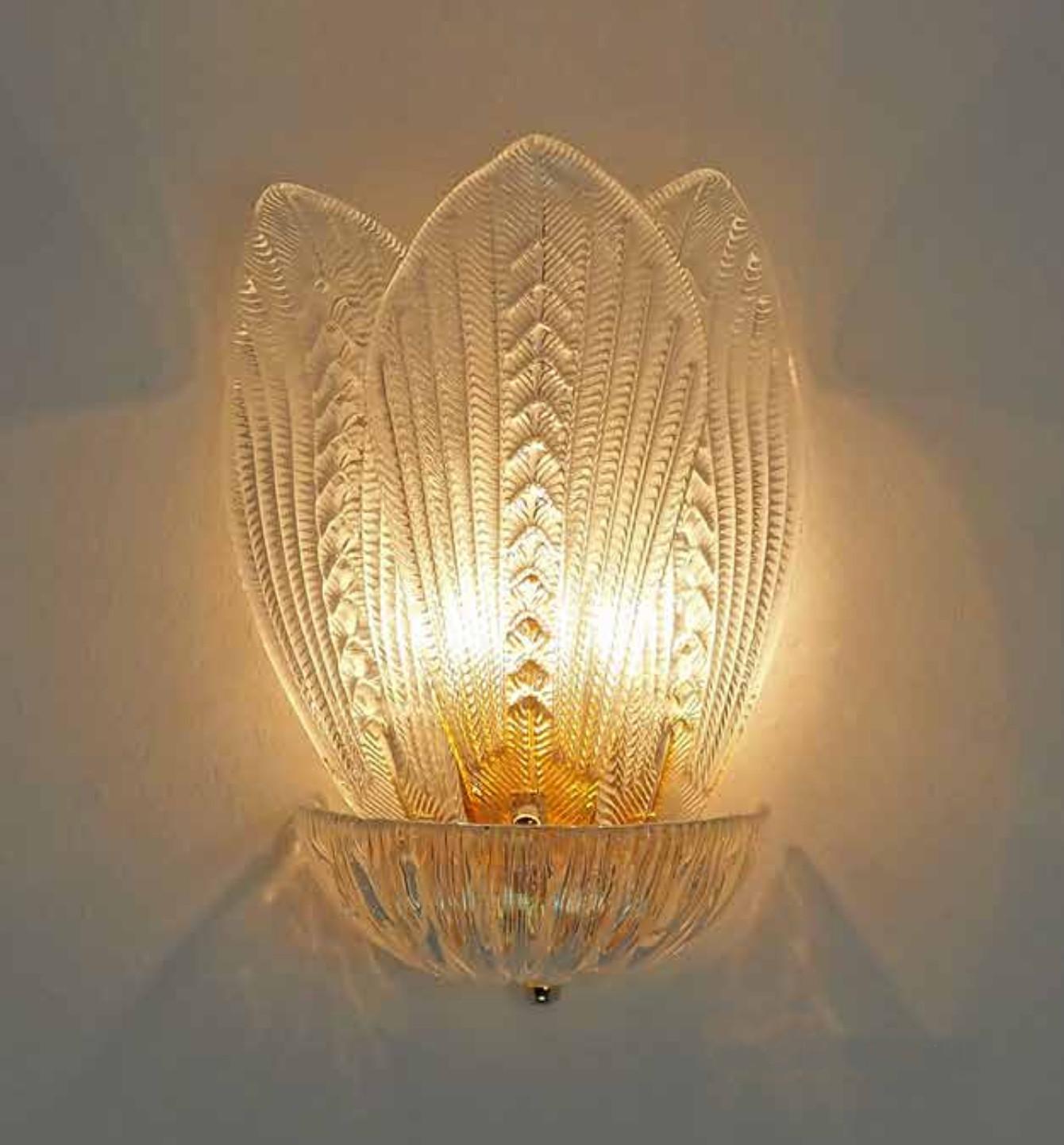 Italian wall light with clear textured Murano glass leaves mounted on 24 K gold plated finish metal frame / Made in Italy in the style of Barovier e Toso
Measures: height 16 inches, width 10.5 inches, depth 7 inches
2 light / E12 or E14 type / max