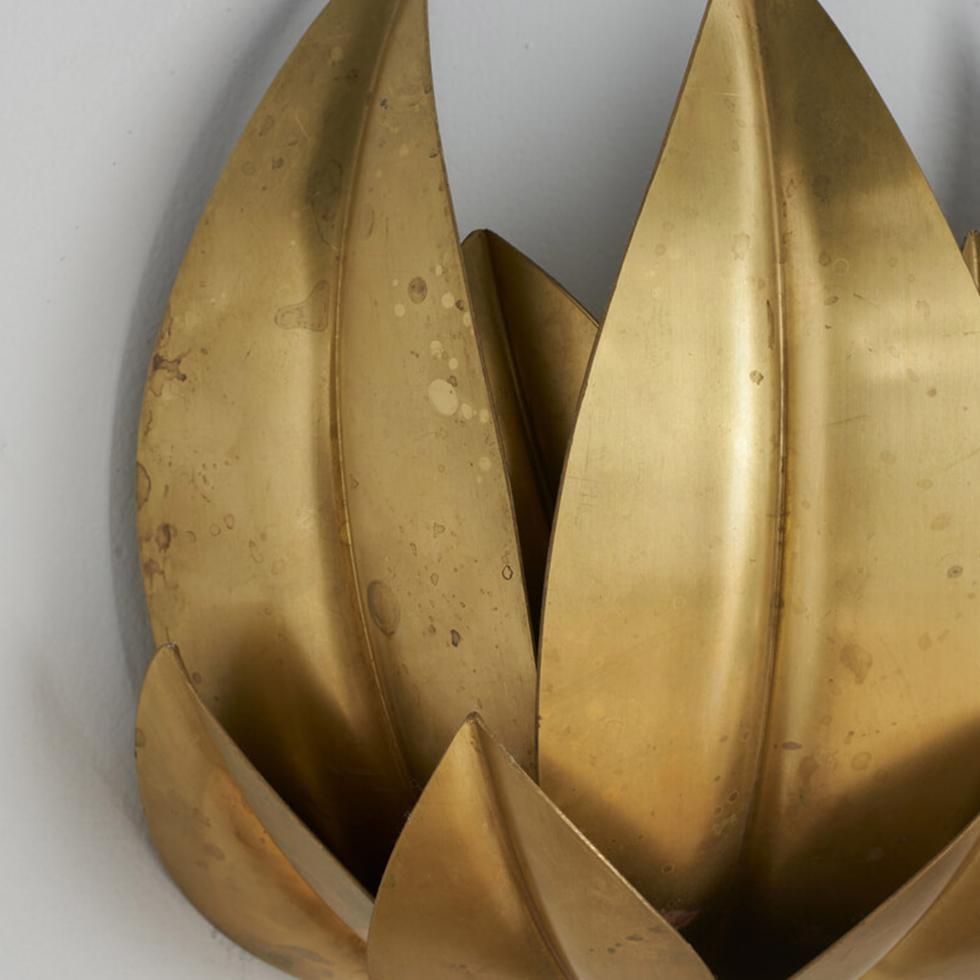The Leaves wall sconce has been conceived and developed in collaboration with the architecture firm Droulers Architecture. It recalls a nest made of brass eucalypt leaves containing an E27 lightbulb. This decorative wall sconce gives a warm and cozy