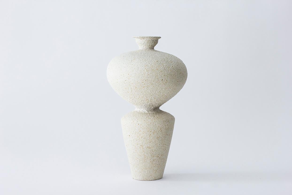 Vaso in gres Lebes Hueso di Raquel Vidal e Pedro Paz.
Dimensioni: 28,5 x 16 cm.
Materiali: Ceramica scolpita a mano e smaltata.

I pezzi sono realizzati a mano in gres bianco con grog, e spazzolati con mix di smalti sperimentali e superficie