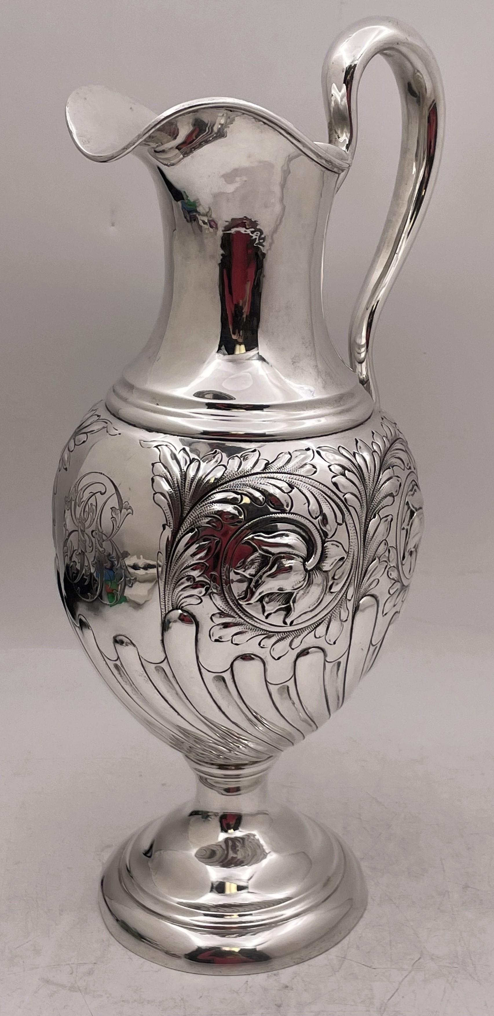 Lebkuecher sterling silver pitcher in Art Nouveau style from the late 19th or early 20th century with raised floral motifs and stylized, fluted motifs adorning the body. It measures 14 5/8'' in height by 7 1/8'' from handle to spout, weighs 27.5