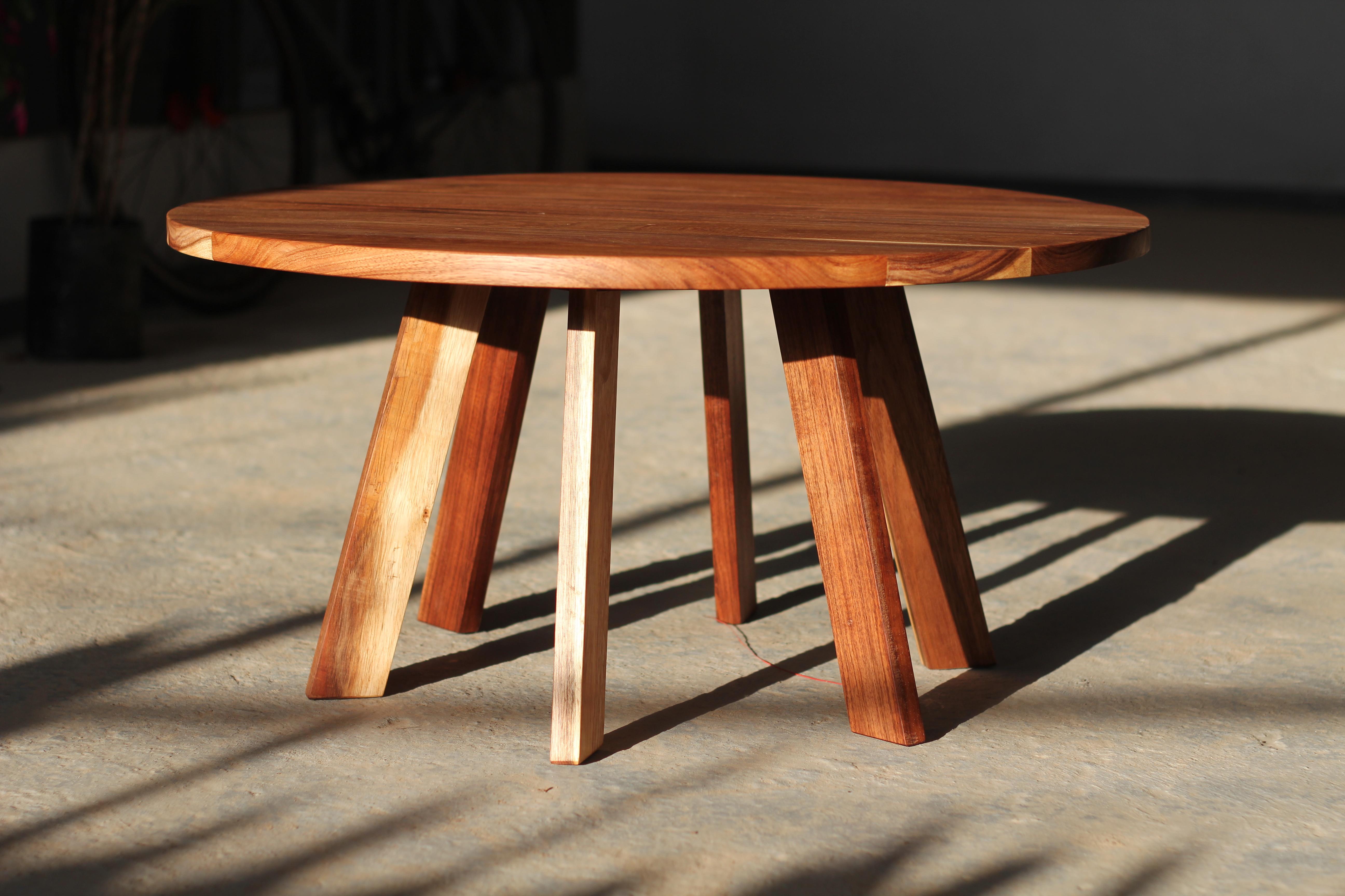 Questo tavolino è realizzato in legno massiccio e si distingue per la sua robustezza e durata. Il suo design è semplice ma imponente, caratterizzato da una base con sei gambe che garantiscono stabilità e un tocco distintivo. La superficie è ampia e