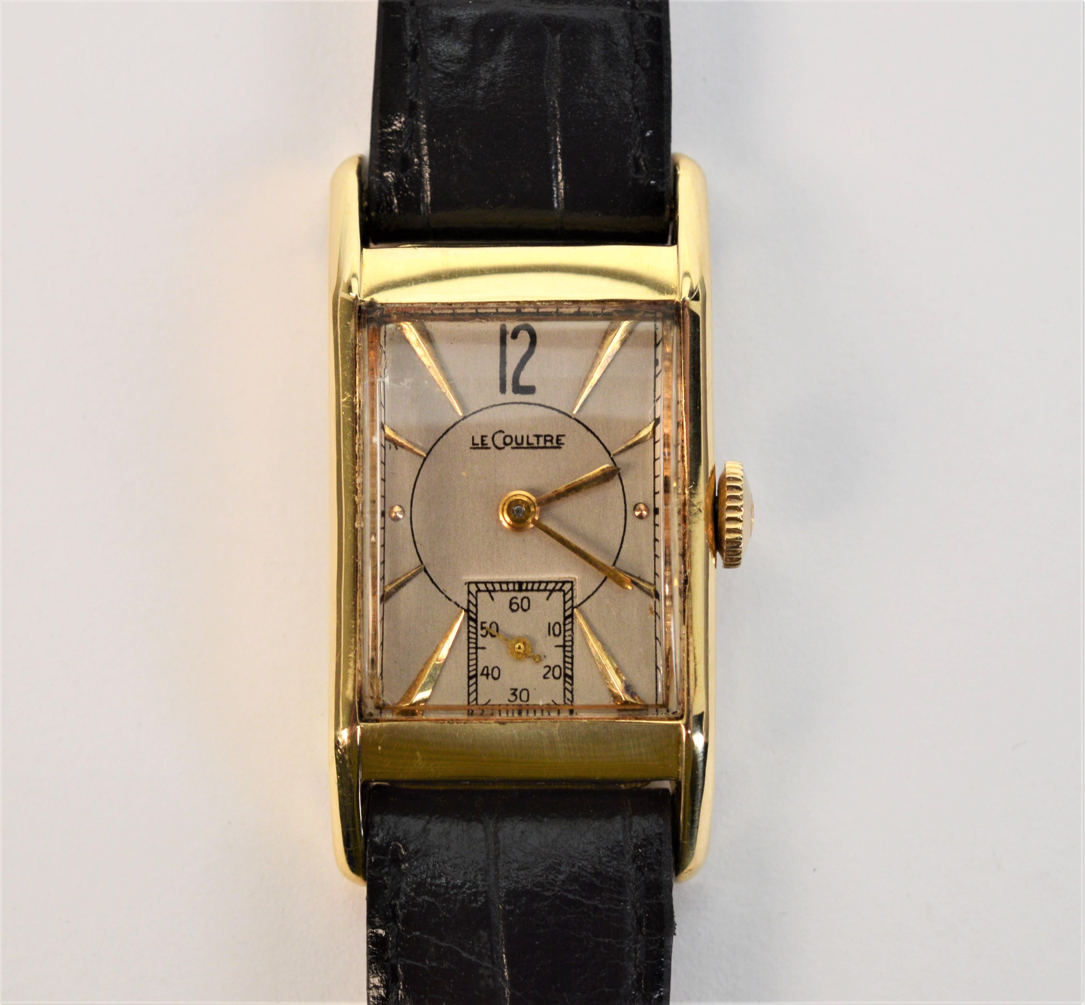 Appreciate the glorious lines of this Art Deco, LeCoultre Model 175 Wrist Watch. Sporting a 14 karat yellow gold rectangular 28 x 20mm case (number 28397), this circa 1940s wrist watch has unique vintage appeal.  On a silver-toned dial, arrow point
