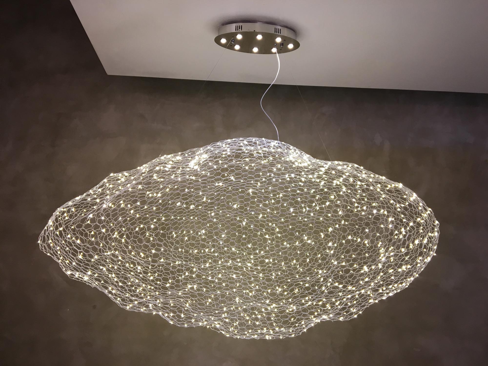 Unique chandelier where hundreds of small LED lights are combined with a handmade wire mesh sculpture shaped like a cloud.
Eight LED lights are mounted on the canopy.
Dimmable.
Finishes: Gold or white. Made in 3 standard sizes(S,M,L).