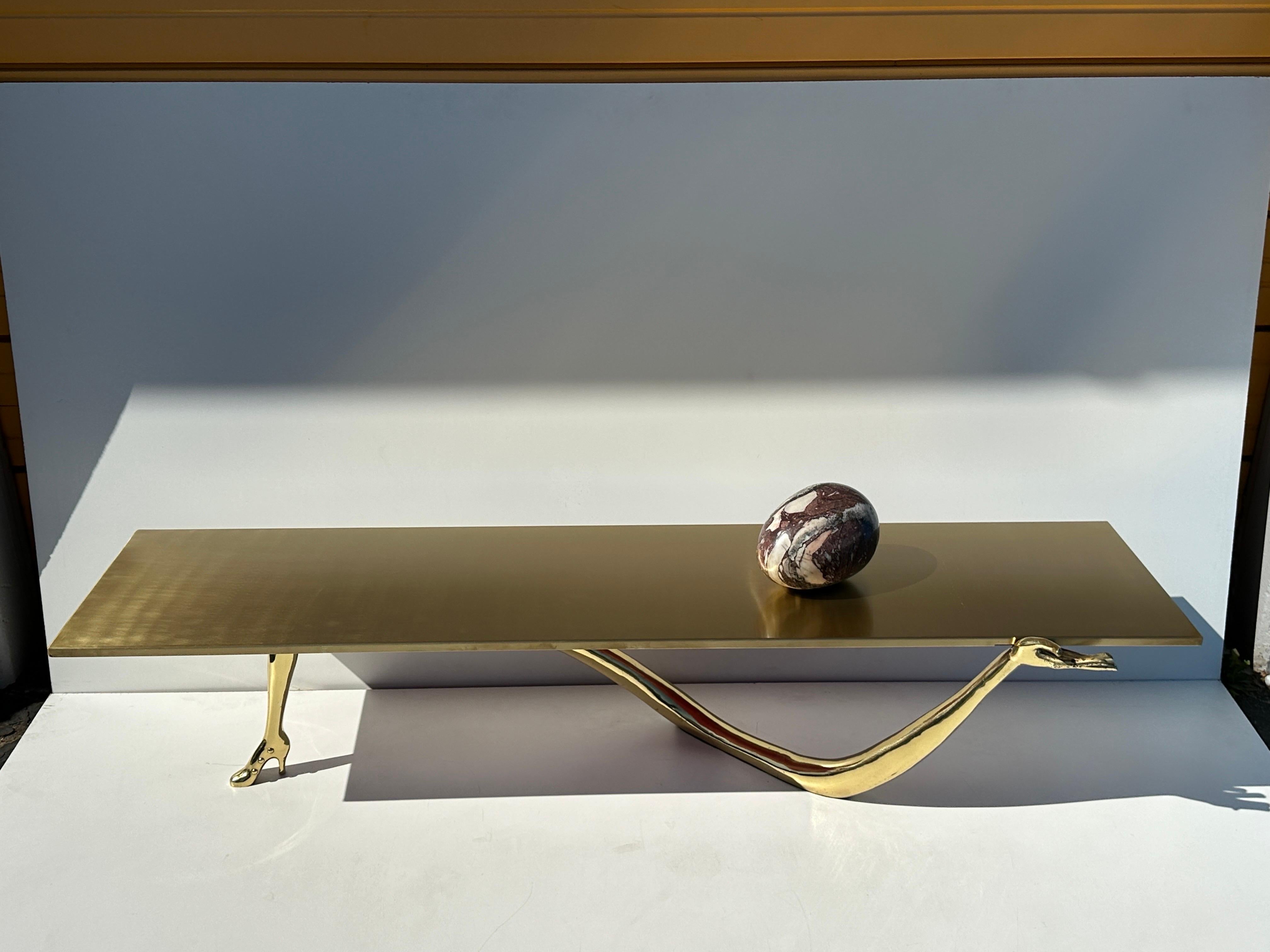 LEDA brass coffee table by Salvador Dali. Beautiful example of Dali’s surrealist hand and high heel sculpture holding a brushed brass table top with a marble egg. Originally designed in 1935, made in 2000s by B. D. Barcelona