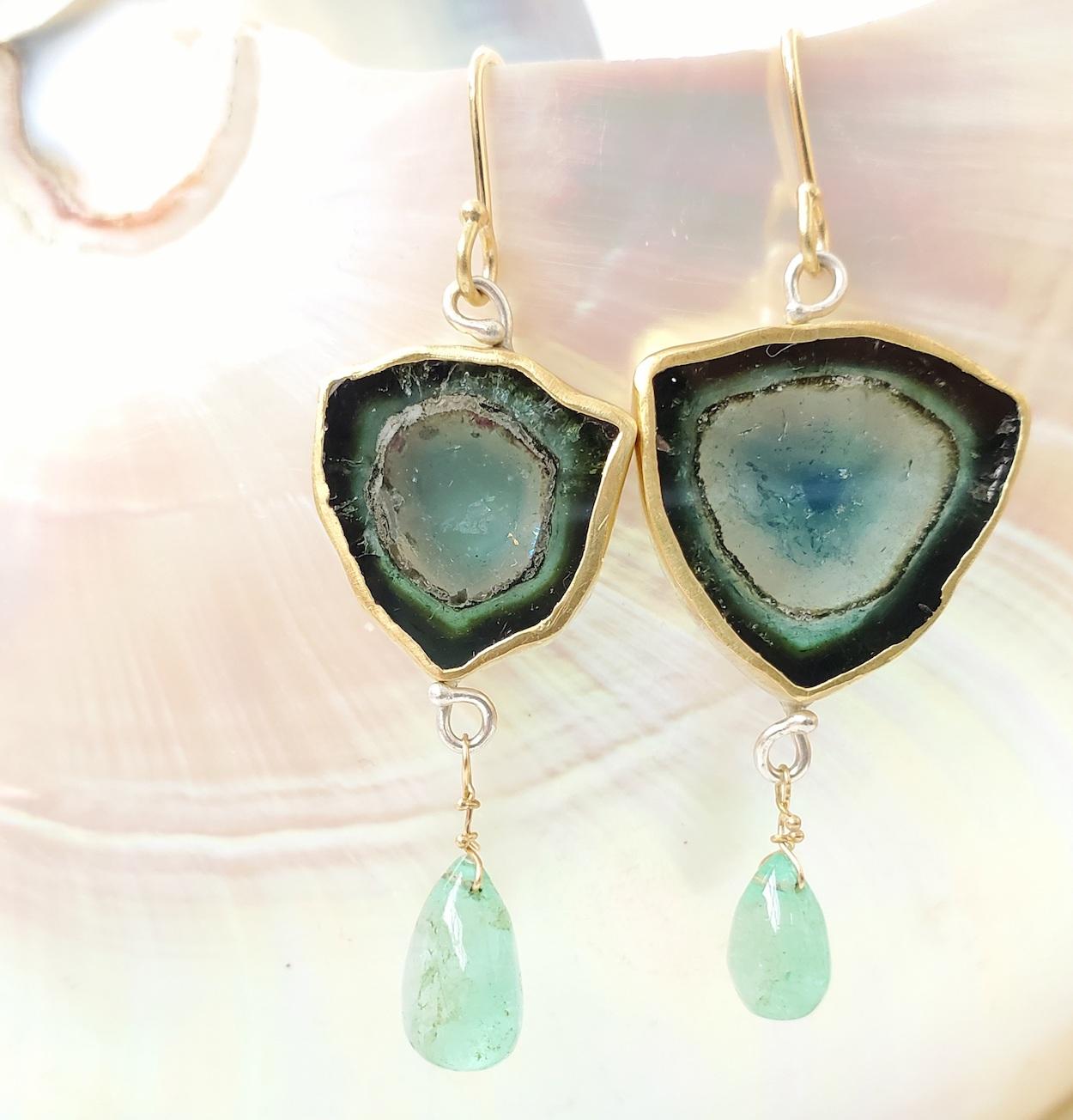 Mis matched indicolite (also known as blue tourmaline) and emerald drop earrings, featuring rare blue crystal slices in shades of deep and pale blue, showcasing the crystal system, with polished emerald briolette drops. Indicolite is the rarest of