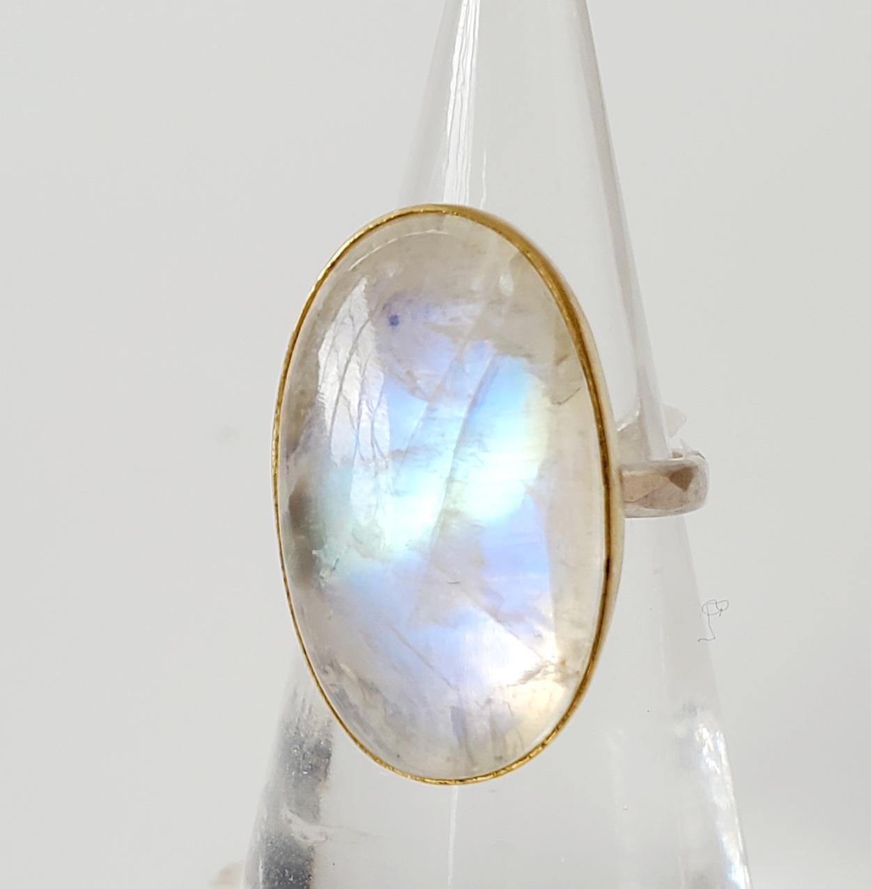 Big oval cabochon rainbow moonstone ring. This natural rainbow moonstone cabochon gemstone, has a lovely, mysterious flash. Handset in a 22K gold bezel, on a sterling silver back and band, with a brush finish. Rainbow moonstone cabochon: 20 carats.