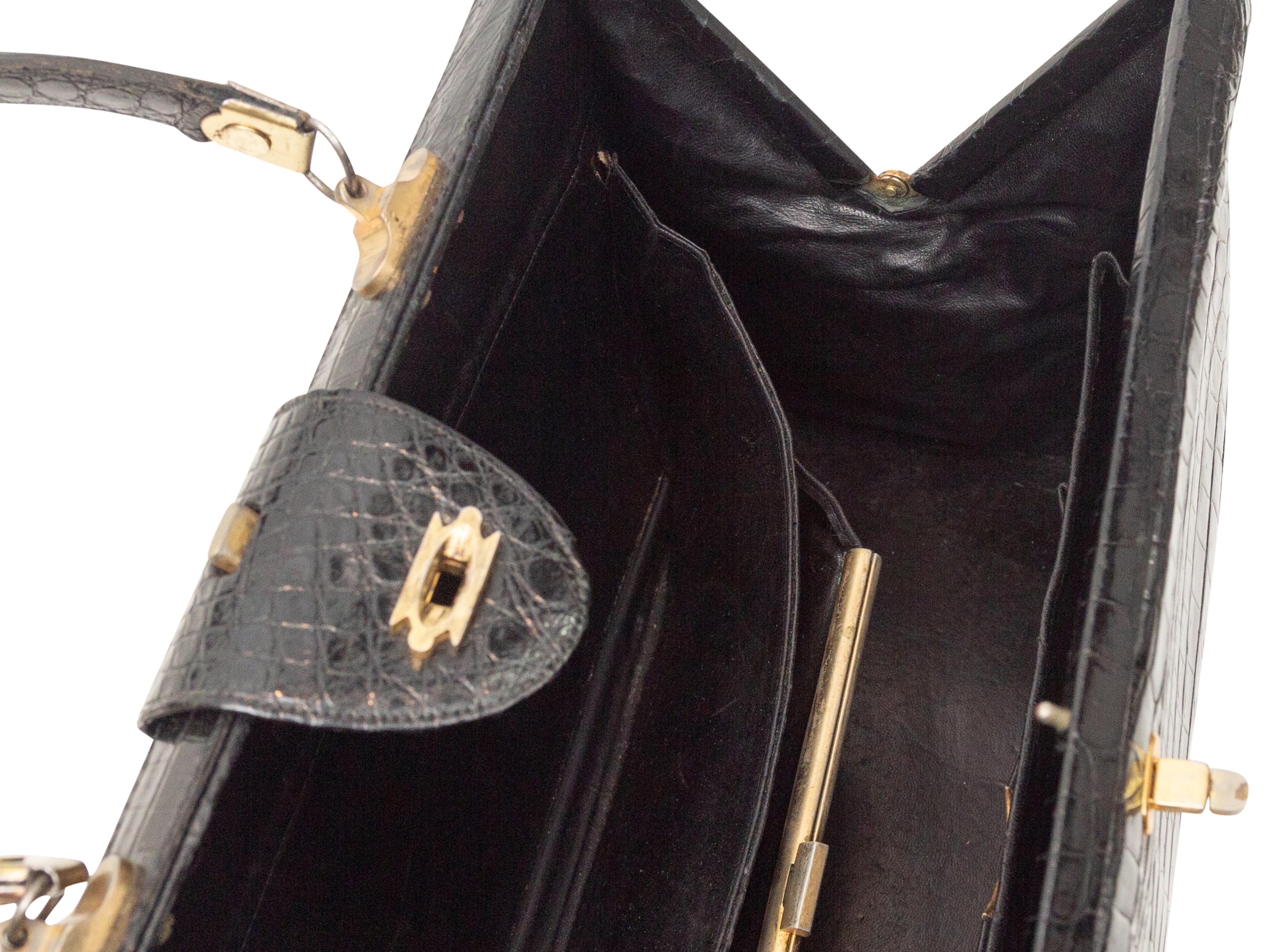 Product Details: Vintage Black Lederer Crocodile Handbag. This handbag features a crocodile body, gold-tone hardware, a single flat top handle, multiple interior pockets, and a clasp closure at the top. 15.25