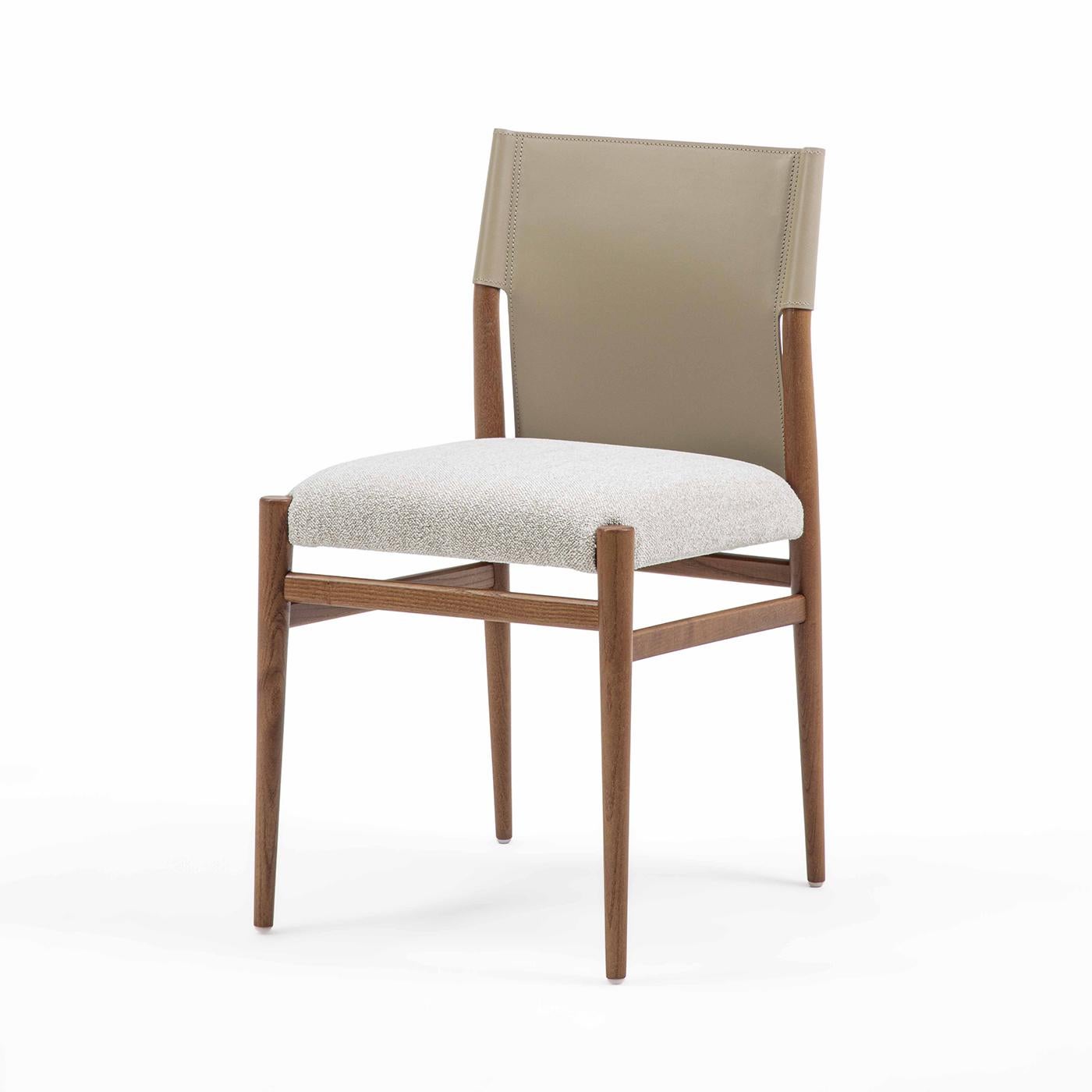 La chaise Ledermann allie élégance et confort avec son design raffiné et ses pieds coniques en bois. Le siège rembourré est revêtu d'un tissu de qualité supérieure, avec une option cuir luxueuse disponible. Le dossier est élégamment enveloppé de